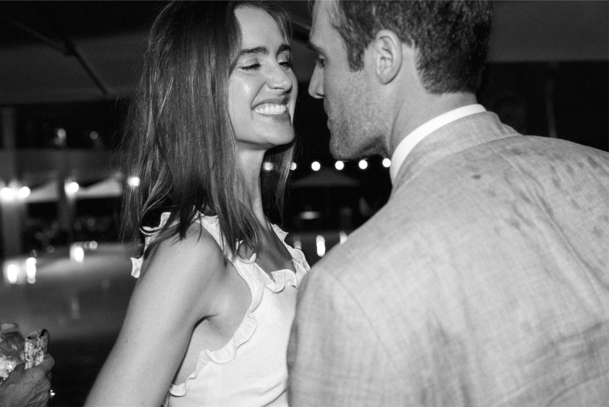 Black and white of the bride laughing with her groom at the reception