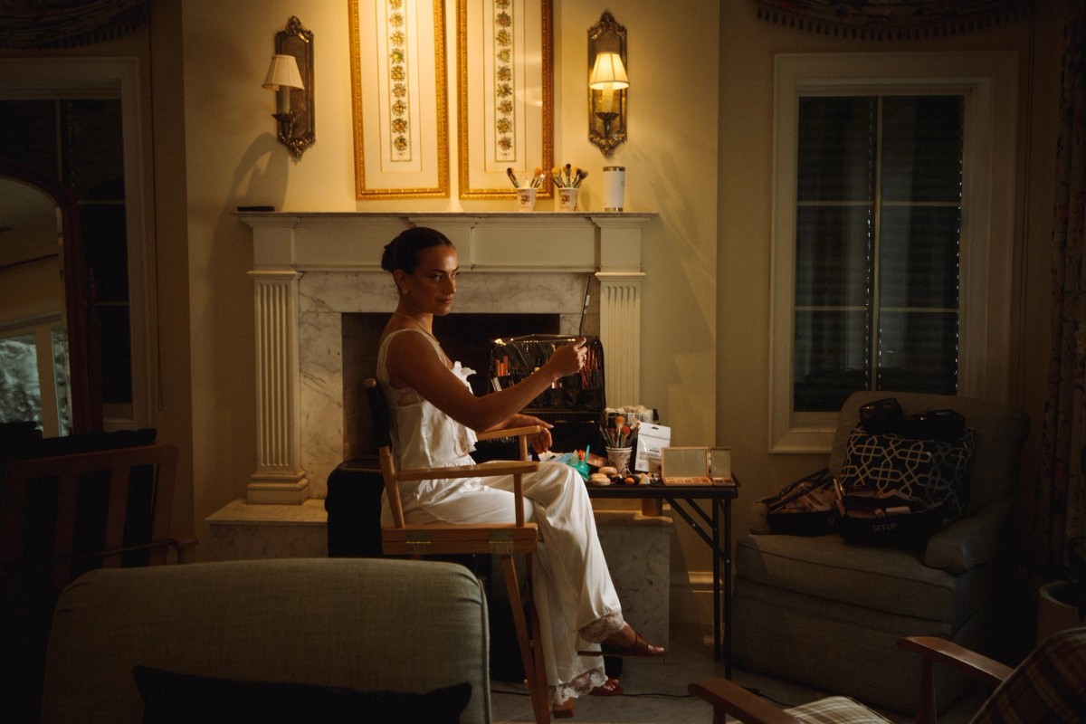 Bride getting ready by the fireplace in a warm lamplit suite at Rosewood Bermuda