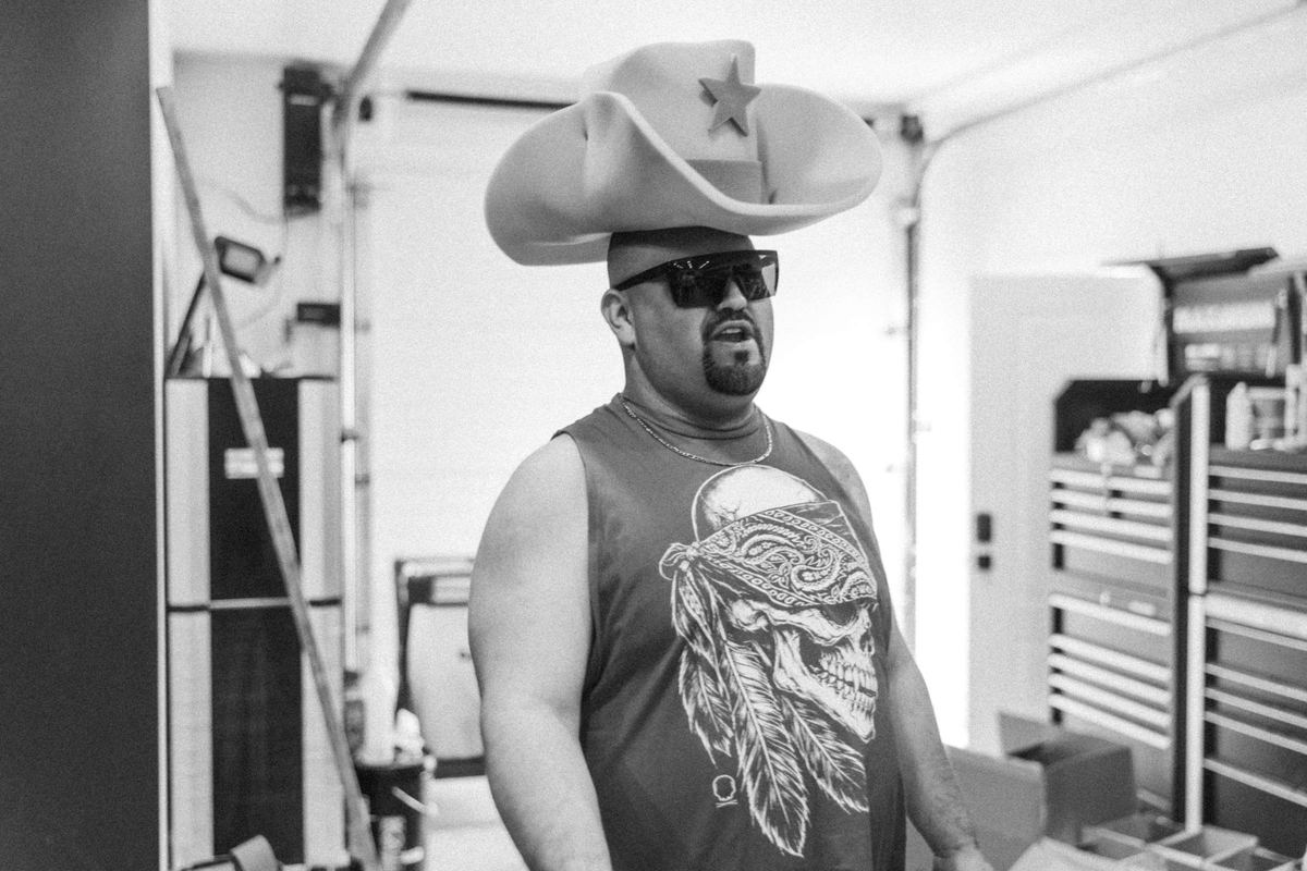 Black and white portrait of a guest in a cowboy hat and sunglasses