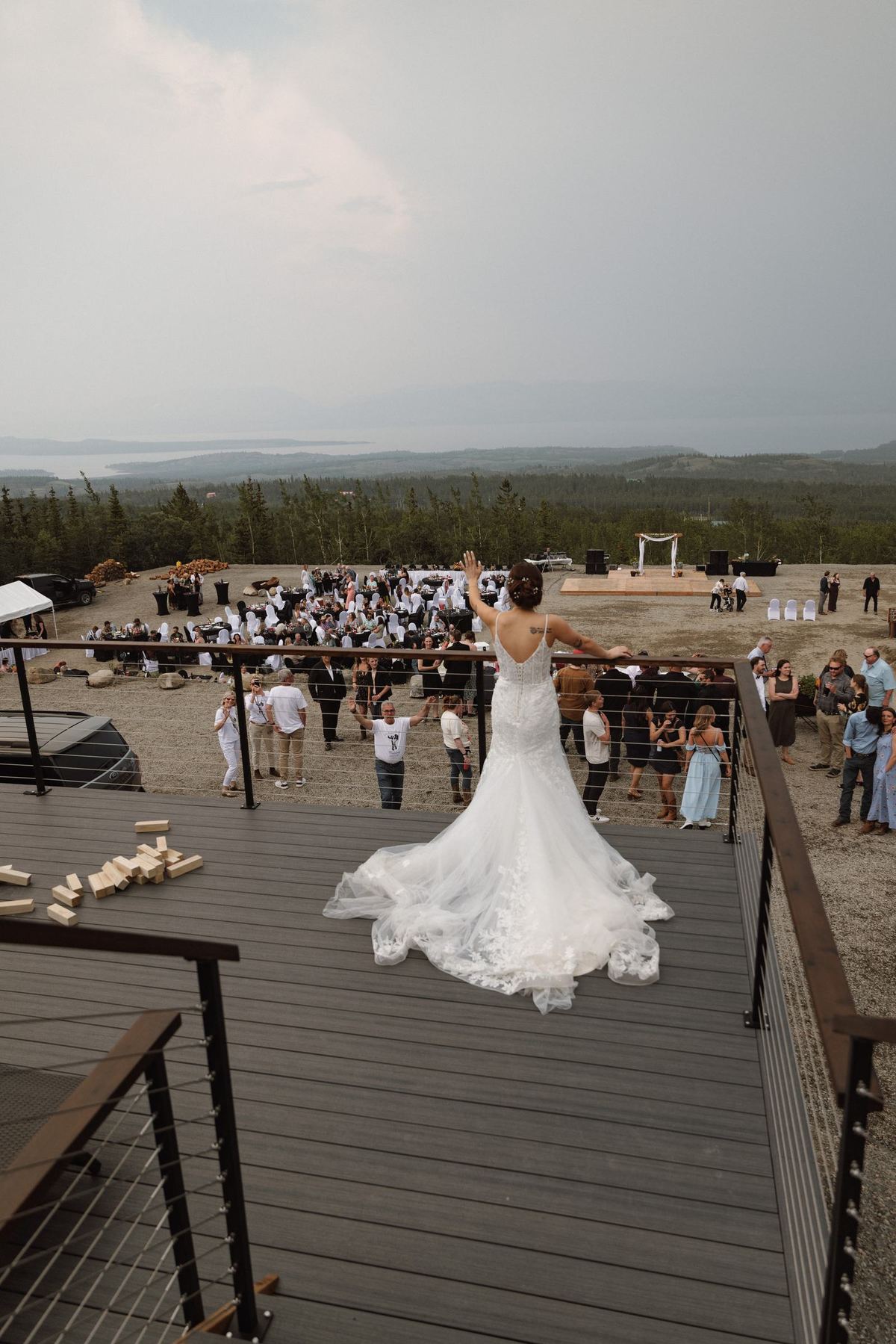 Overhead view of the bride's dress spread across the wooden deck