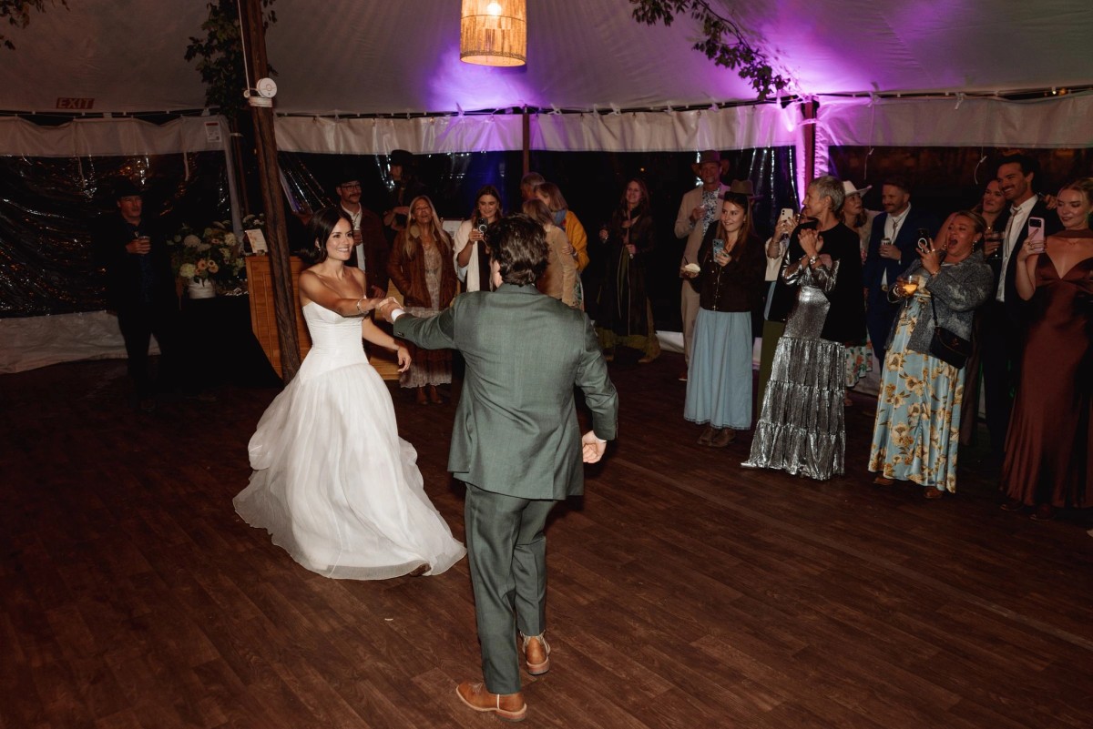 Owen spins Devin on the dance floor under the tent at a mountain ranch among the aspens