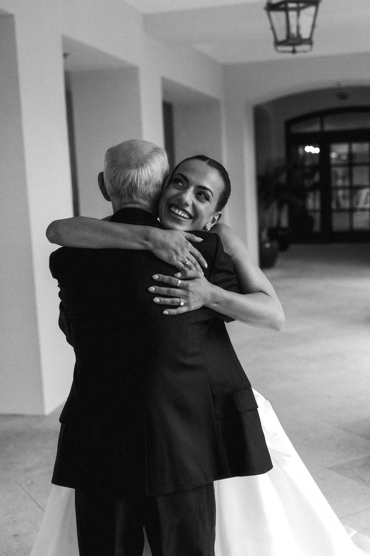 Bride hugging her father after their first look at Rosewood Bermuda, black and white