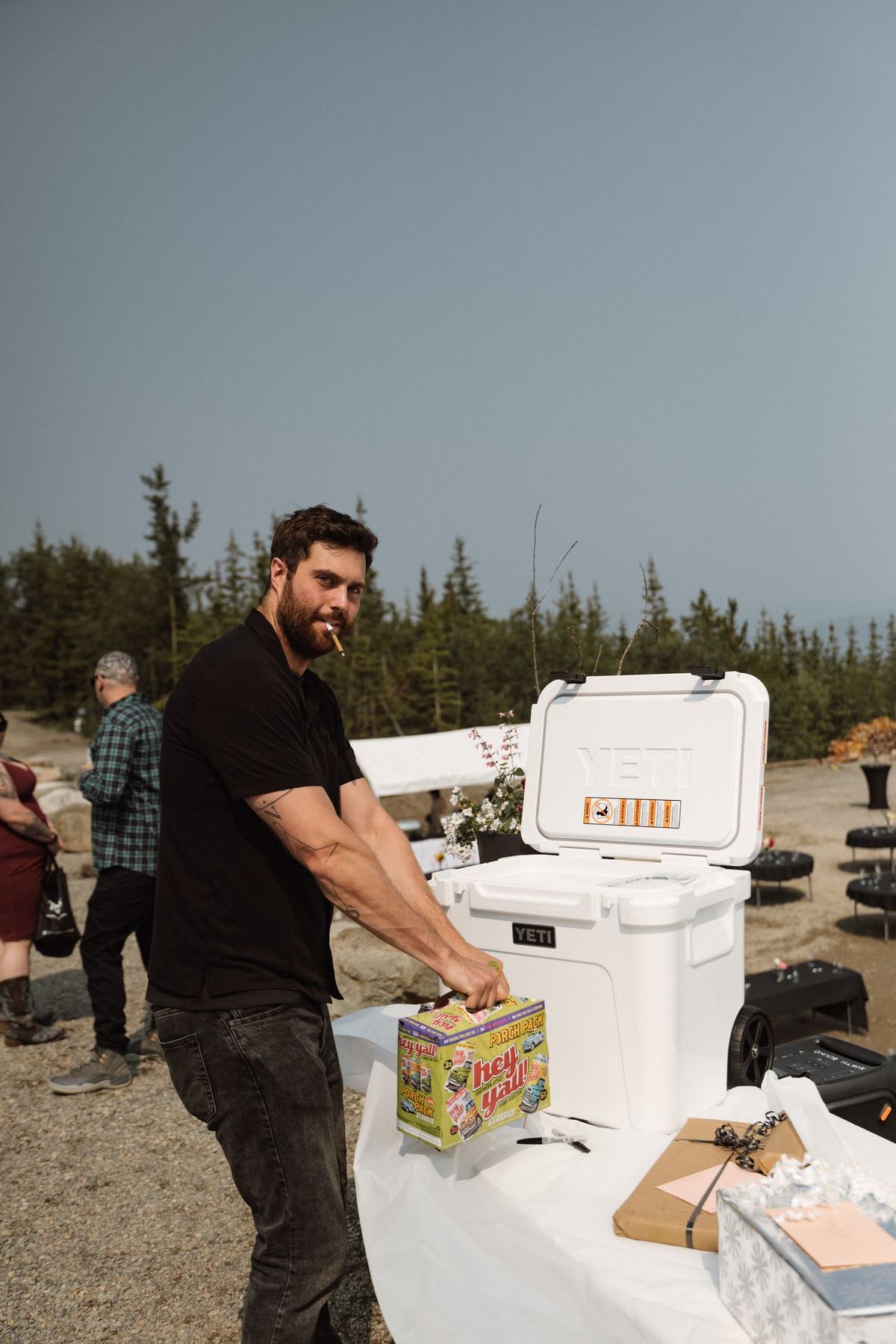 Friend setting up drinks and coolers before a mountaintop wedding ceremony