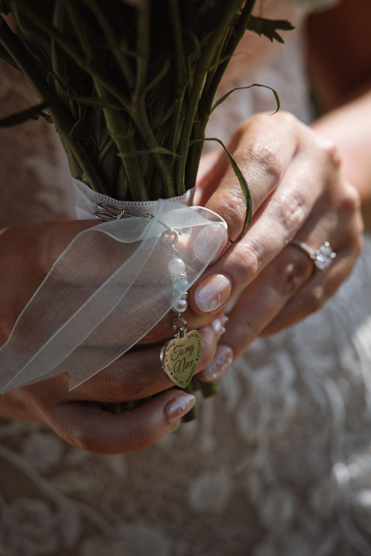 Close-up detail of hand resting on lace wedding gown texture