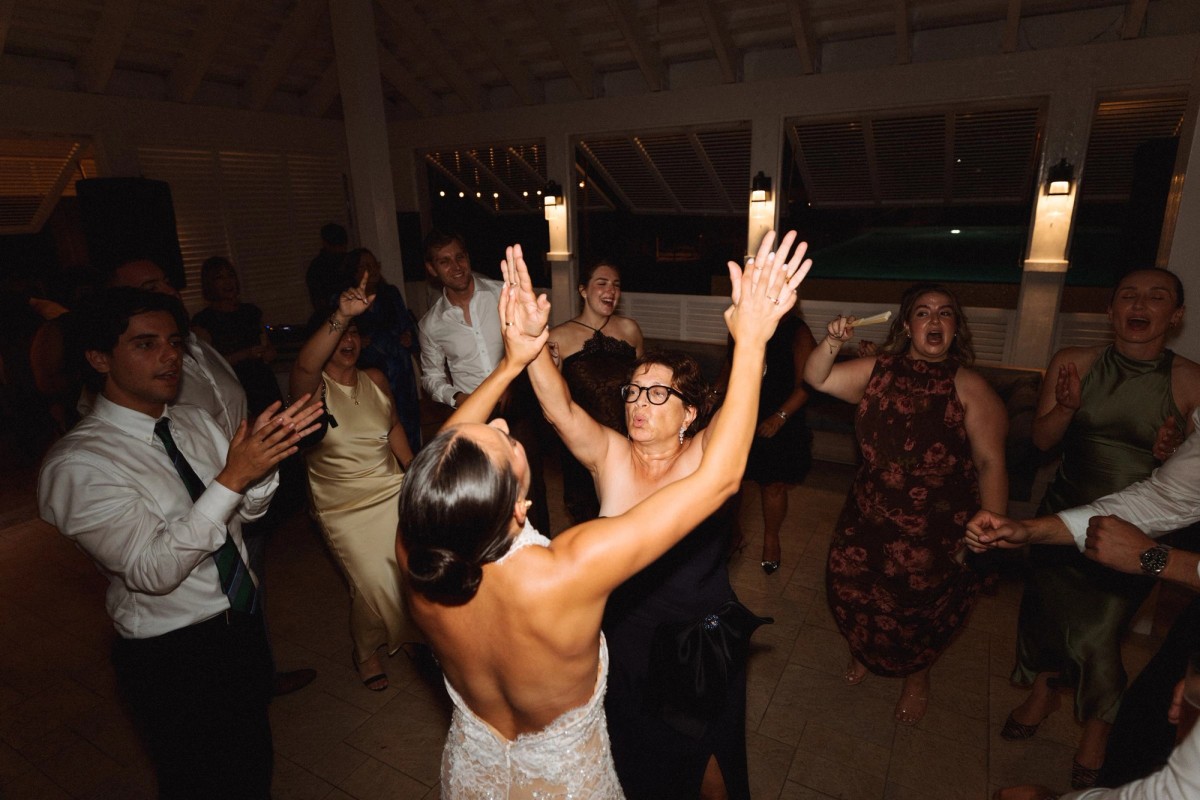 Bride with her arms up on a packed dance floor at Rosewood Bermuda