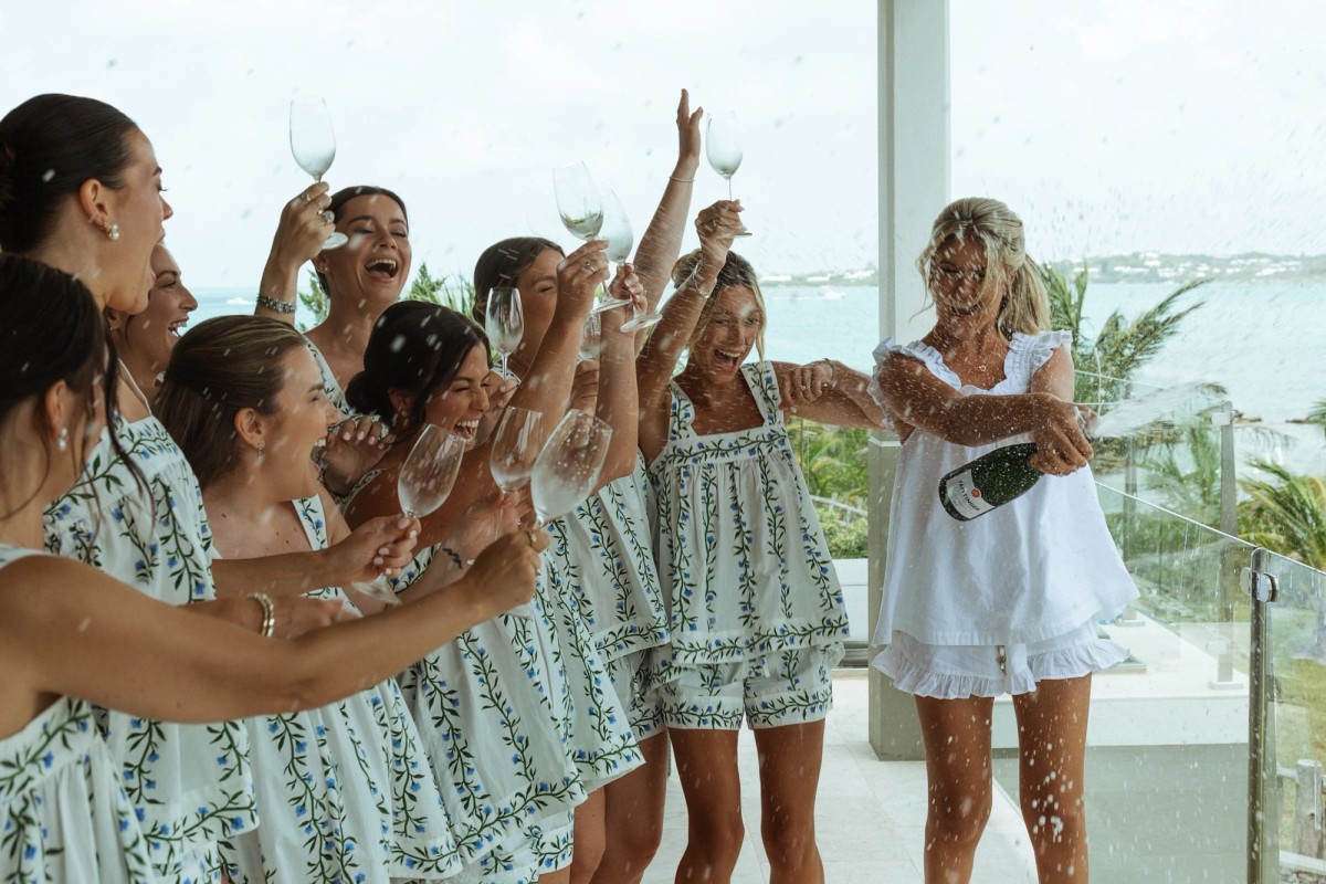 Champagne sprays as Paige and her bridesmaids celebrate by the window on Hawkins Island, Bermuda