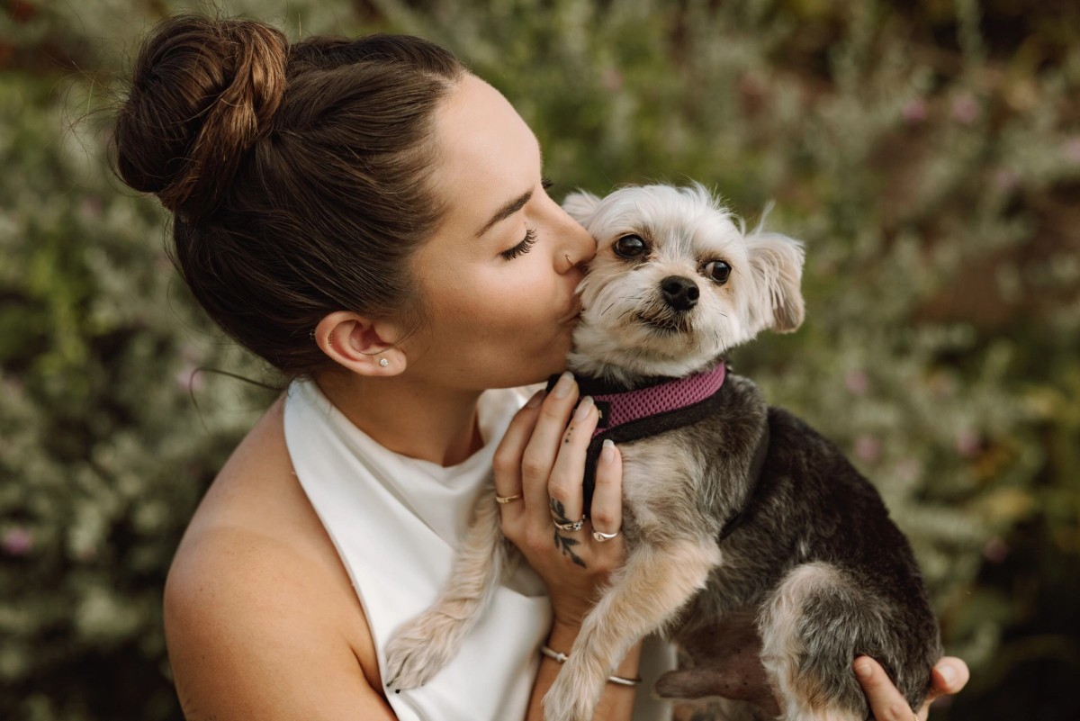 Bride kissing the couple's dog in a Bermuda garden