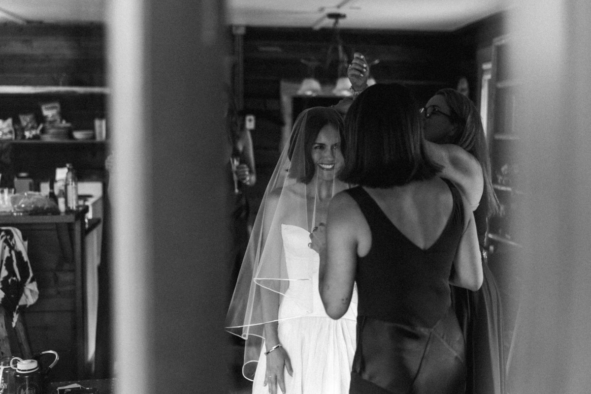 Devin smiles as her veil is set in the cabin kitchen at a mountain ranch among the aspens, black and white