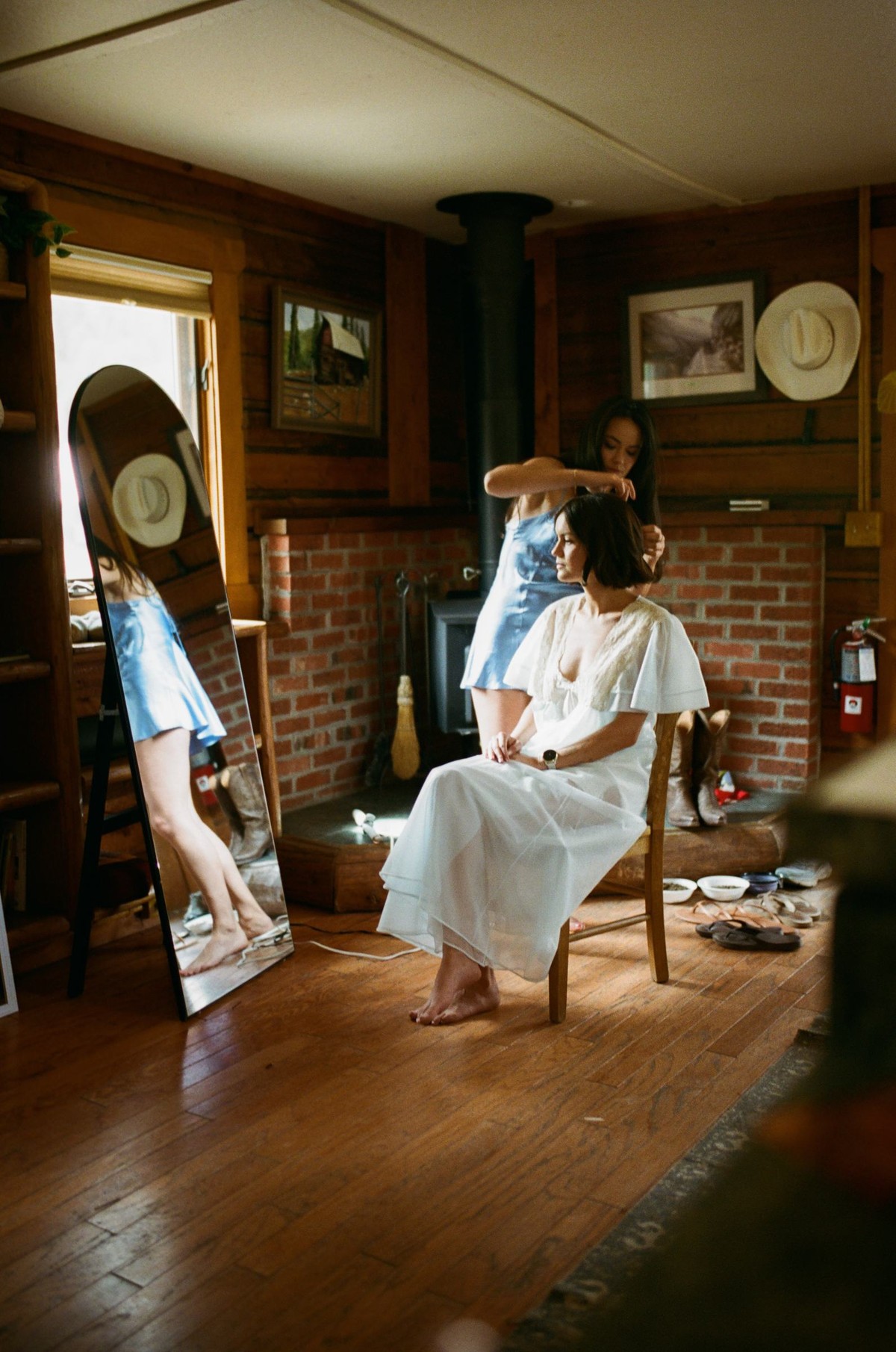 Devin getting ready by the fireplace in the log cabin, shot on film at a mountain ranch among the aspens