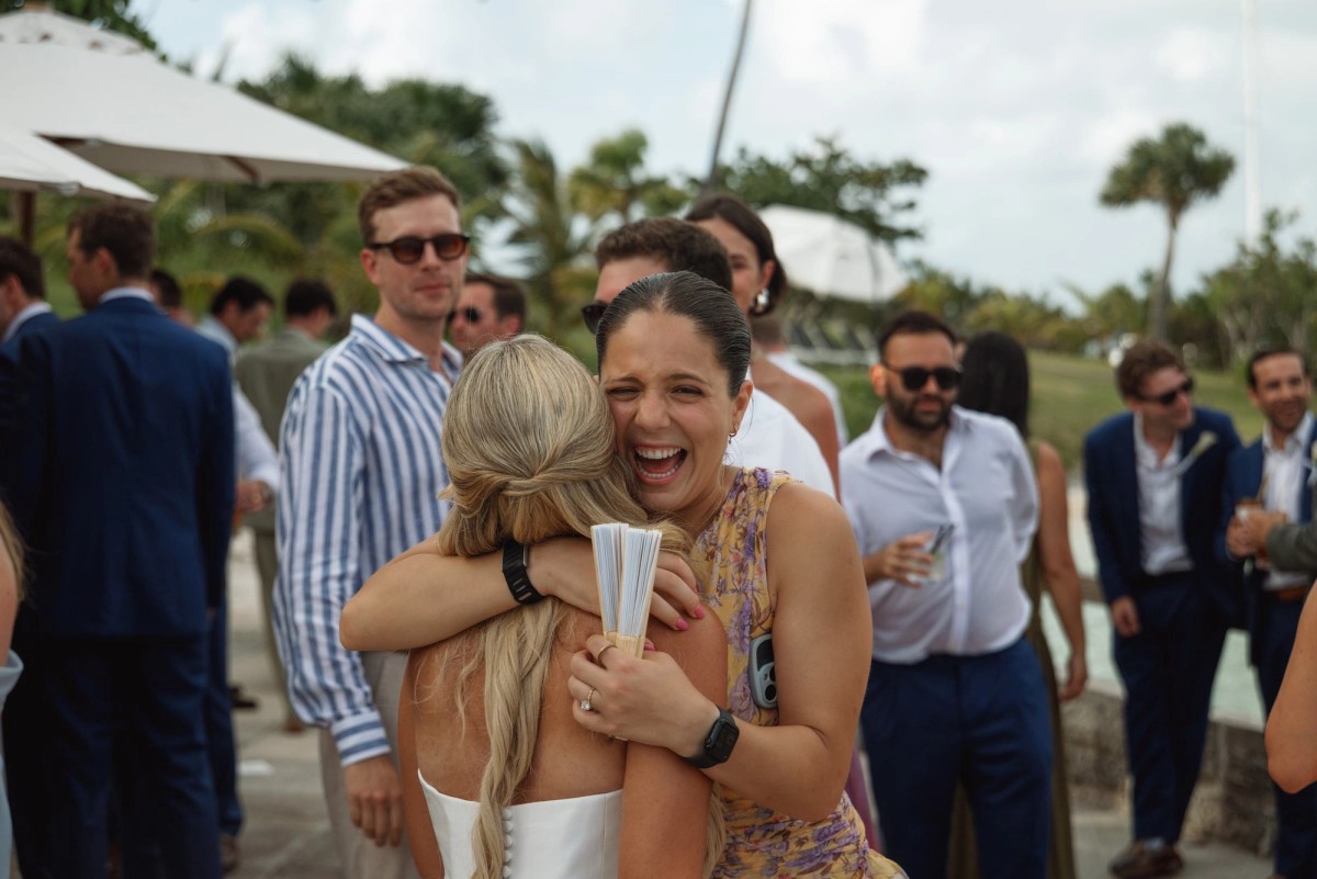A guest hugs Paige and laughs during cocktail hour on Hawkins Island, Bermuda