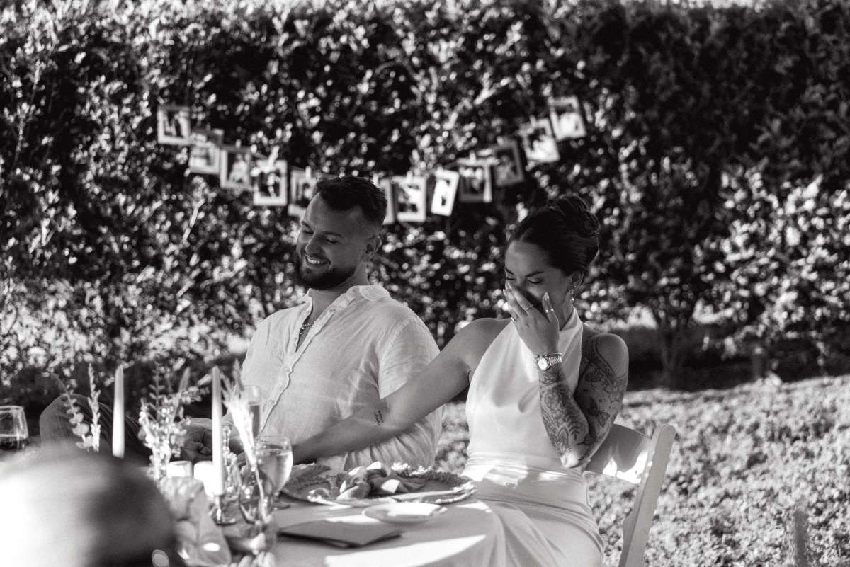 Black and white photograph of the couple laughing together at the dinner table
