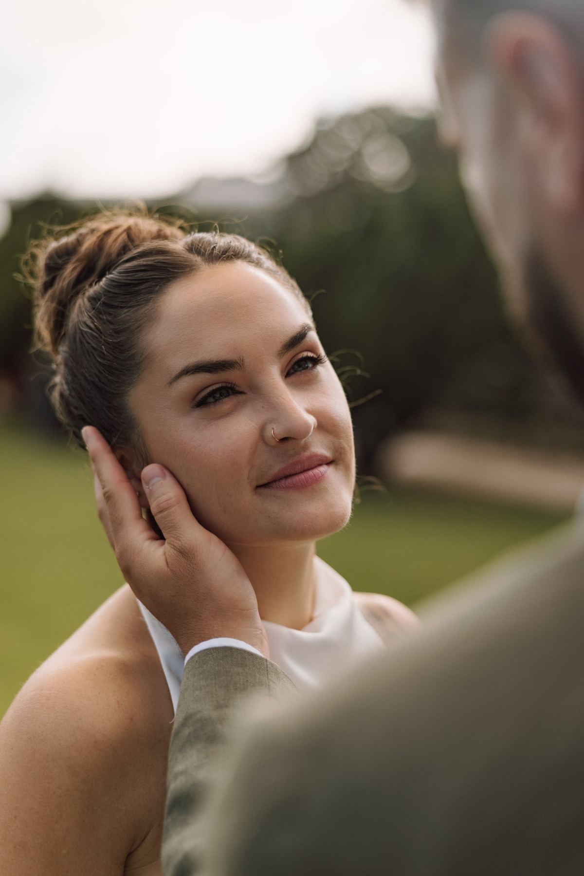 Bride's face with the groom's hand resting on her cheek