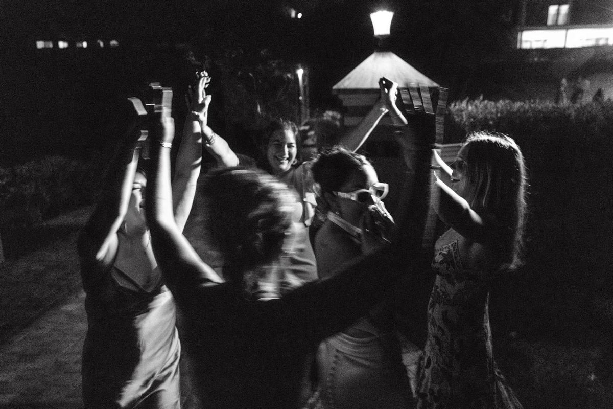 Black and white photograph of hands and sparklers raised on the dance floor