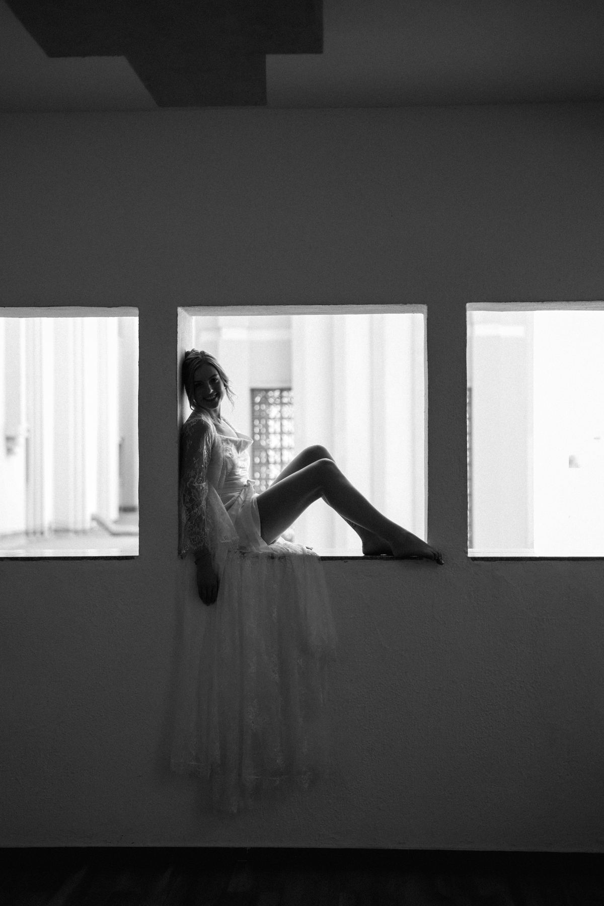 Bride silhouette in window light, black and white wedding photography