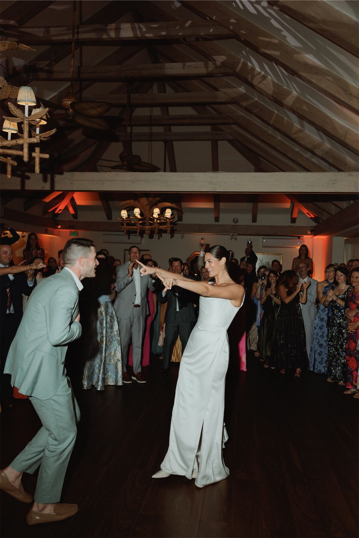 First dance in a timbered ballroom while guests circle the floor