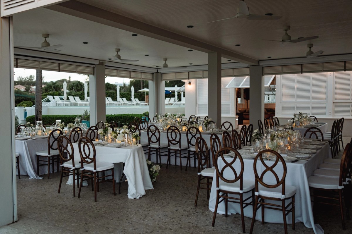 Covered terrace set for the reception with cross back chairs at Rosewood Bermuda