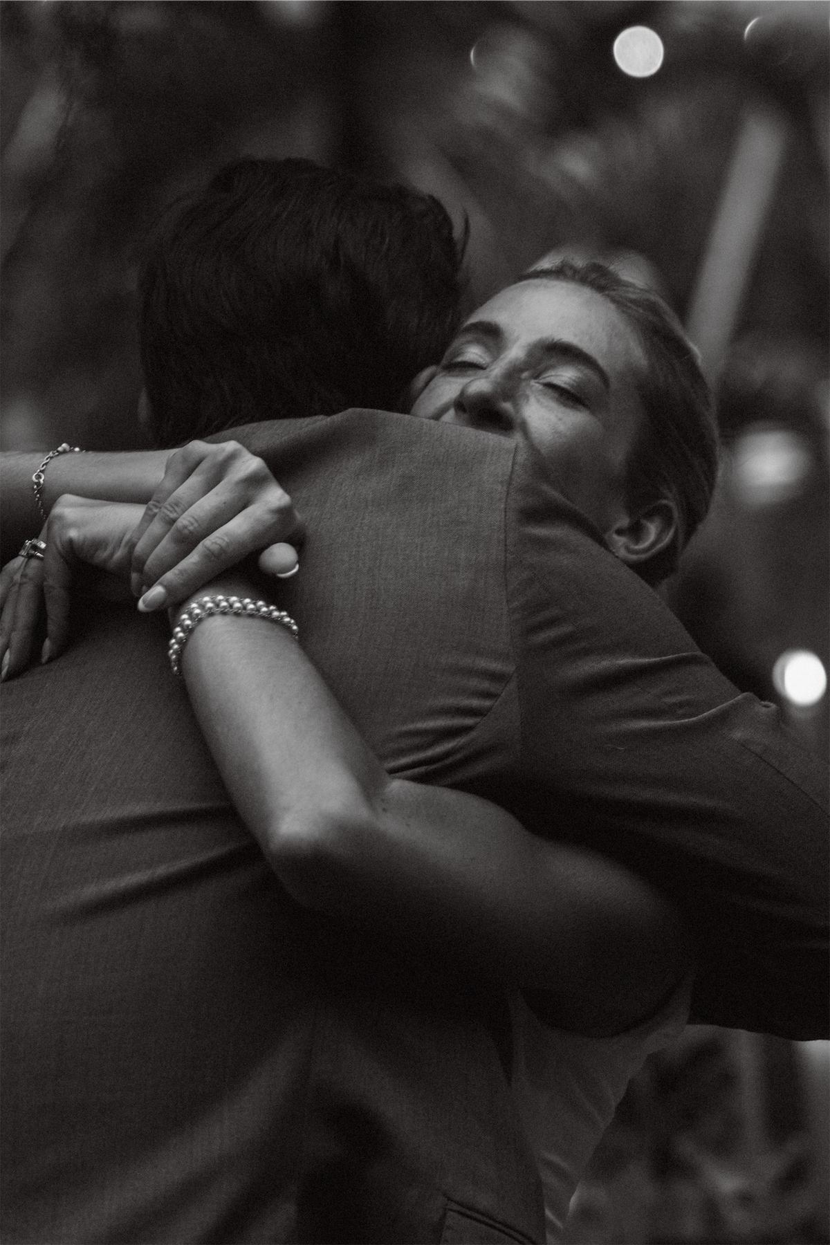 Black and white of the bride hugging a friend tightly on the dance floor