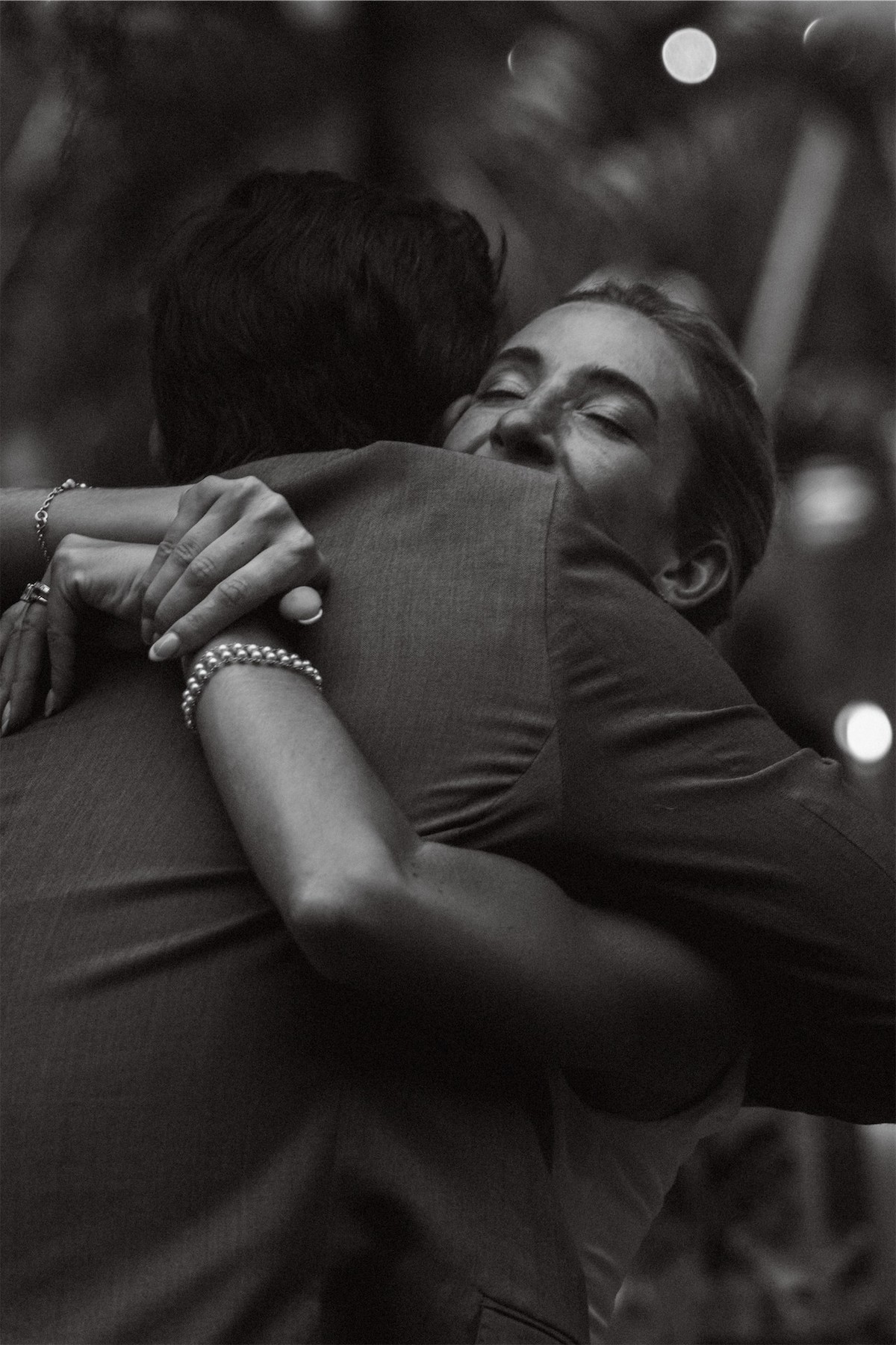 Black and white of the bride hugging a friend tightly on the dance floor