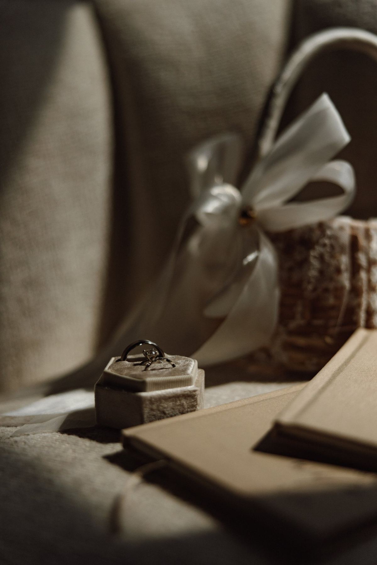 Ring box and vow books resting on linen before the ceremony