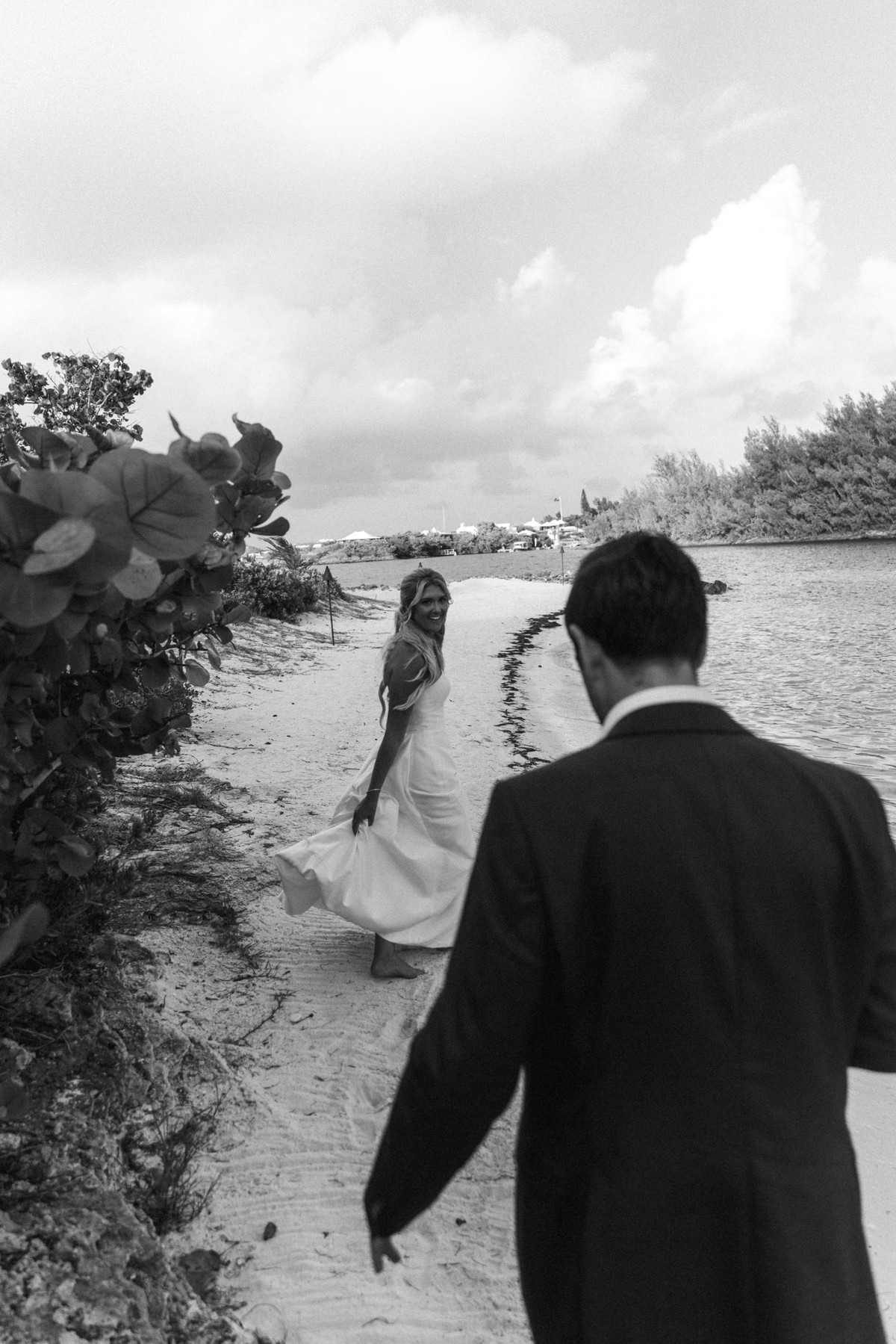Paige walks the sandy path ahead of Cam toward the water on Hawkins Island, Bermuda, black and white