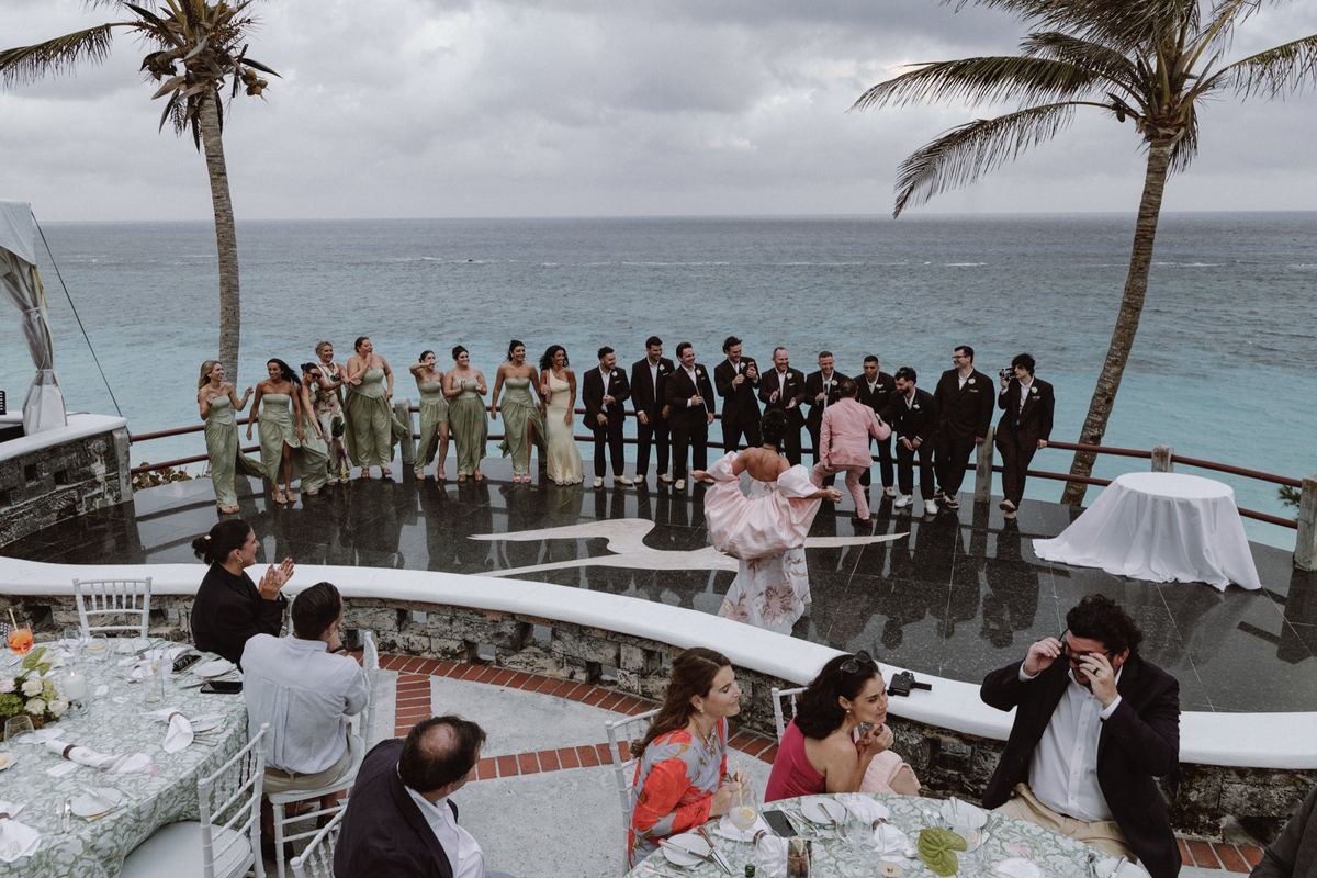 Spontaneous guest performance overlooking the ocean at wedding reception