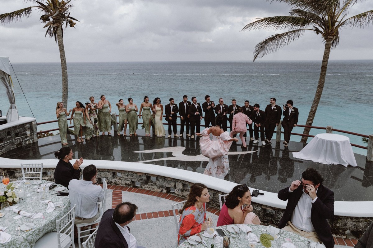 Spontaneous guest performance overlooking the ocean at wedding reception