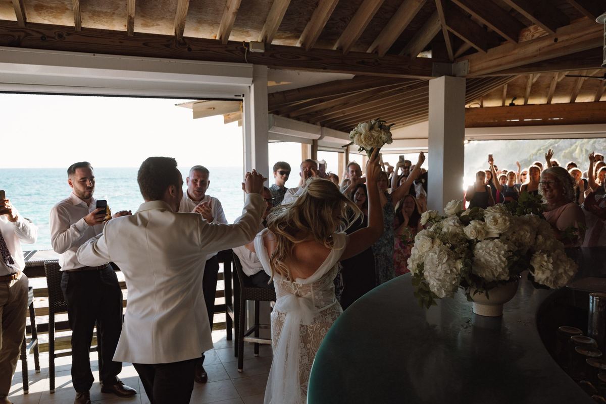 Wide first dance moment under string lights at Bermuda wedding reception