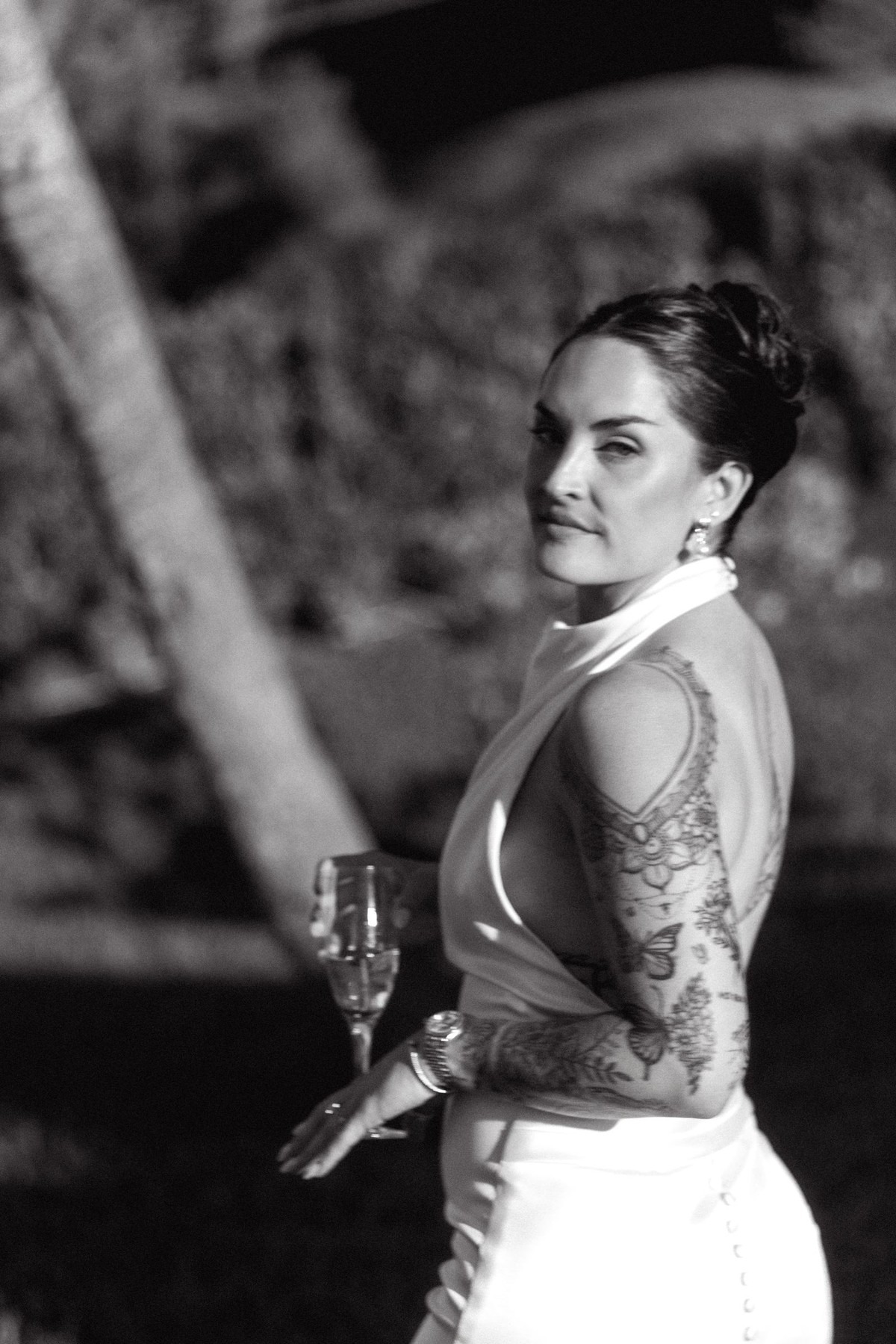 Black and white photograph of the bride in profile with a glass of champagne