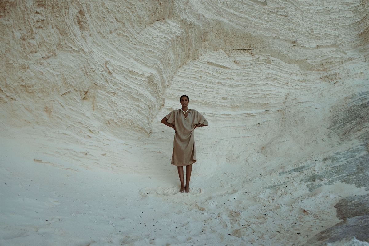 Small figure in a linen dress dwarfed by towering white cliffs