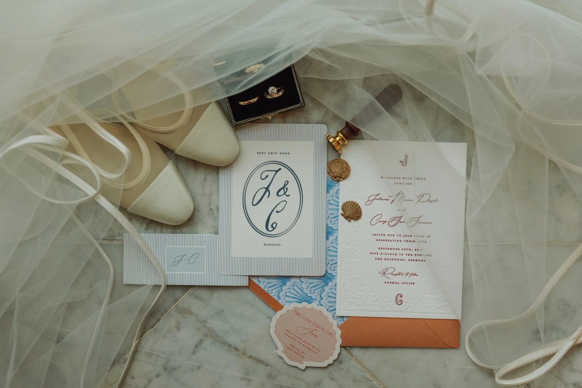 Wedding invitation, rings and satin shoes laid on a tulle veil at Rosewood Bermuda