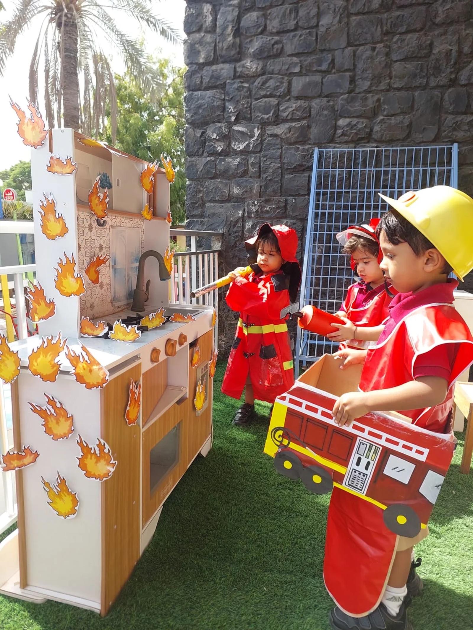 Children pretending to be firefighters with a play fire engine