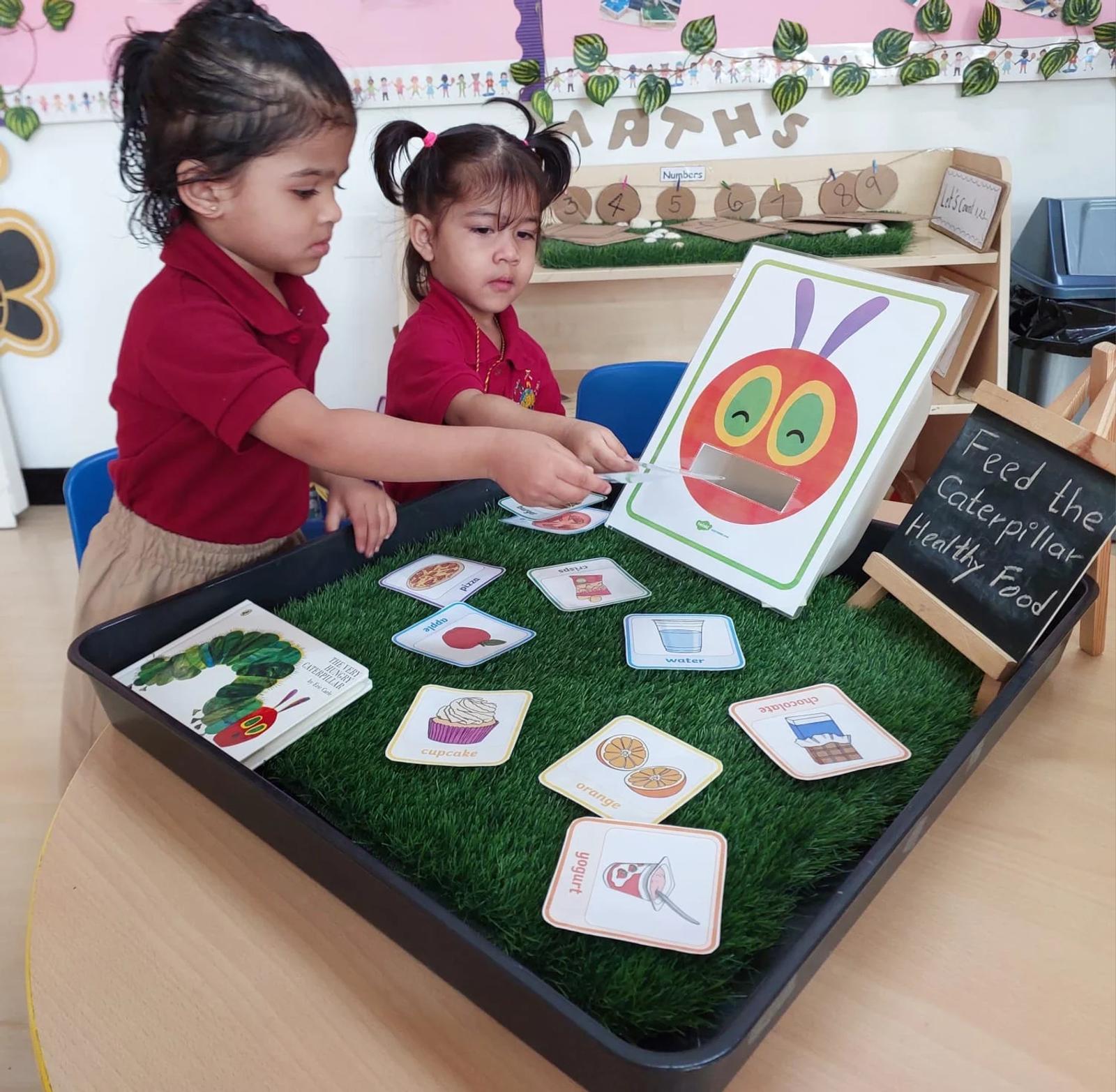 Children exploring a caterpillar story with picture cards