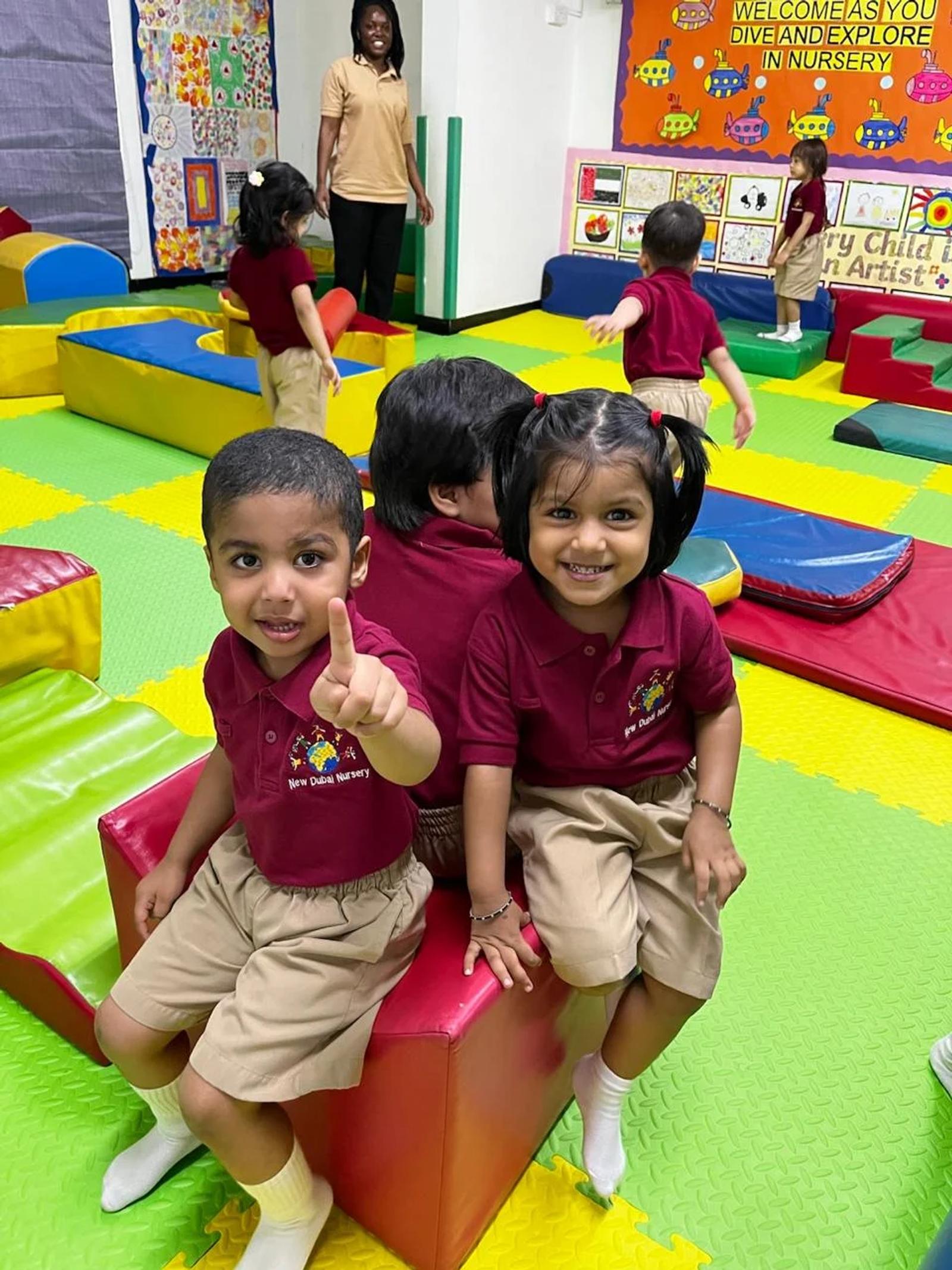 Two children smiling together in the soft play area