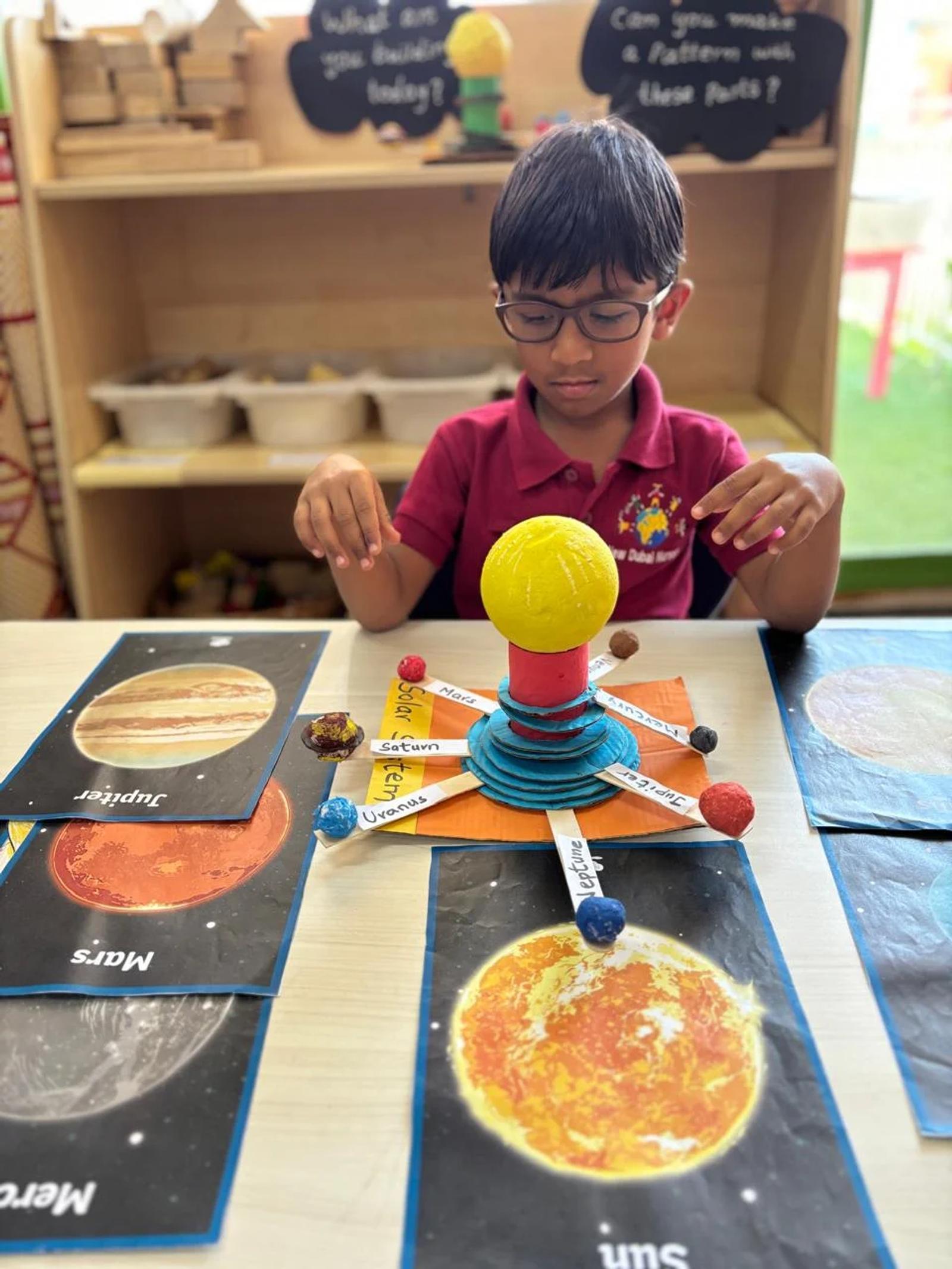 A child exploring a model of the solar system
