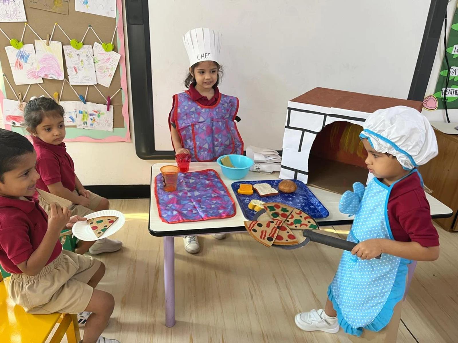 Children playing together in a classroom pretend kitchen