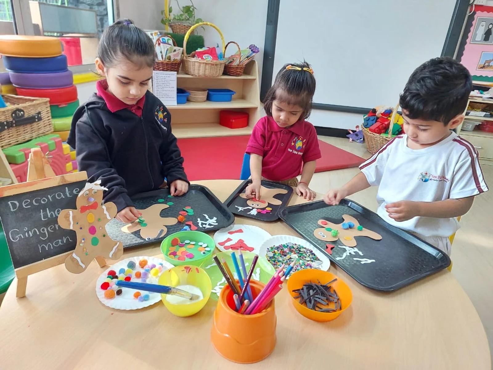 Children decorating gingerbread-shaped crafts with colourful materials