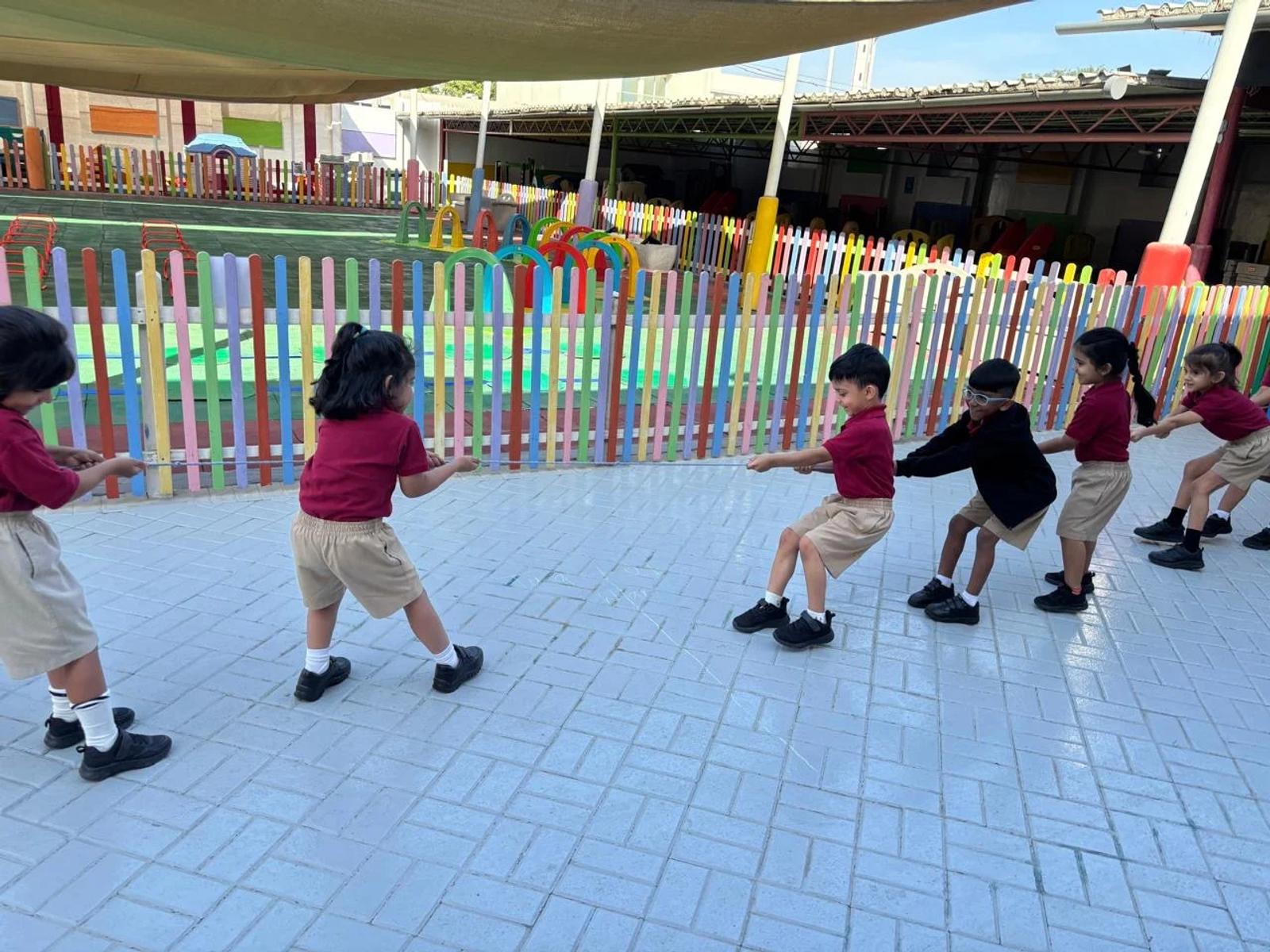 Children moving together across the shaded nursery playground