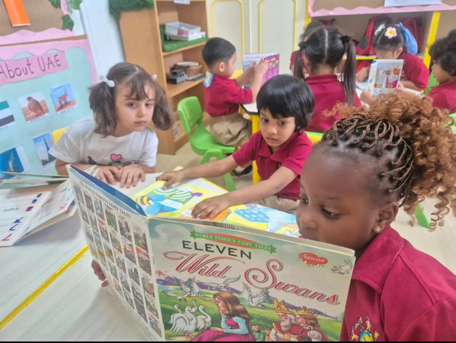 Children exploring picture books around a classroom table