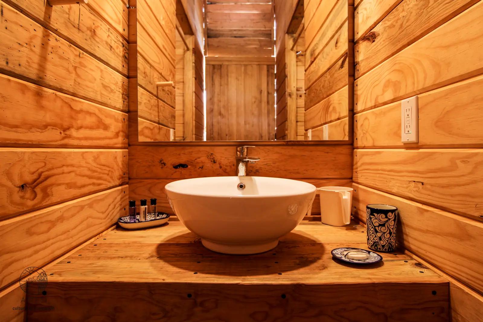 Private bathroom inside an Attesi glamping tent with a wood-clad interior and handmade soaps