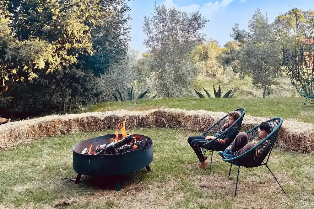 2 kids sitting by the fire