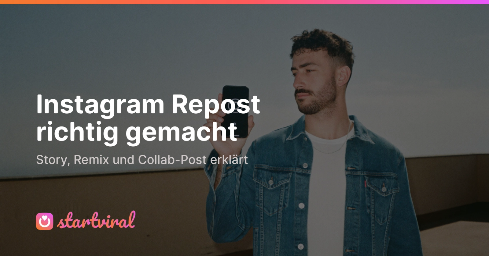 Mann in Jeansjacke steht auf einer Dachterrasse und hält sein Handy hoch, tippt auf den Bildschirm.