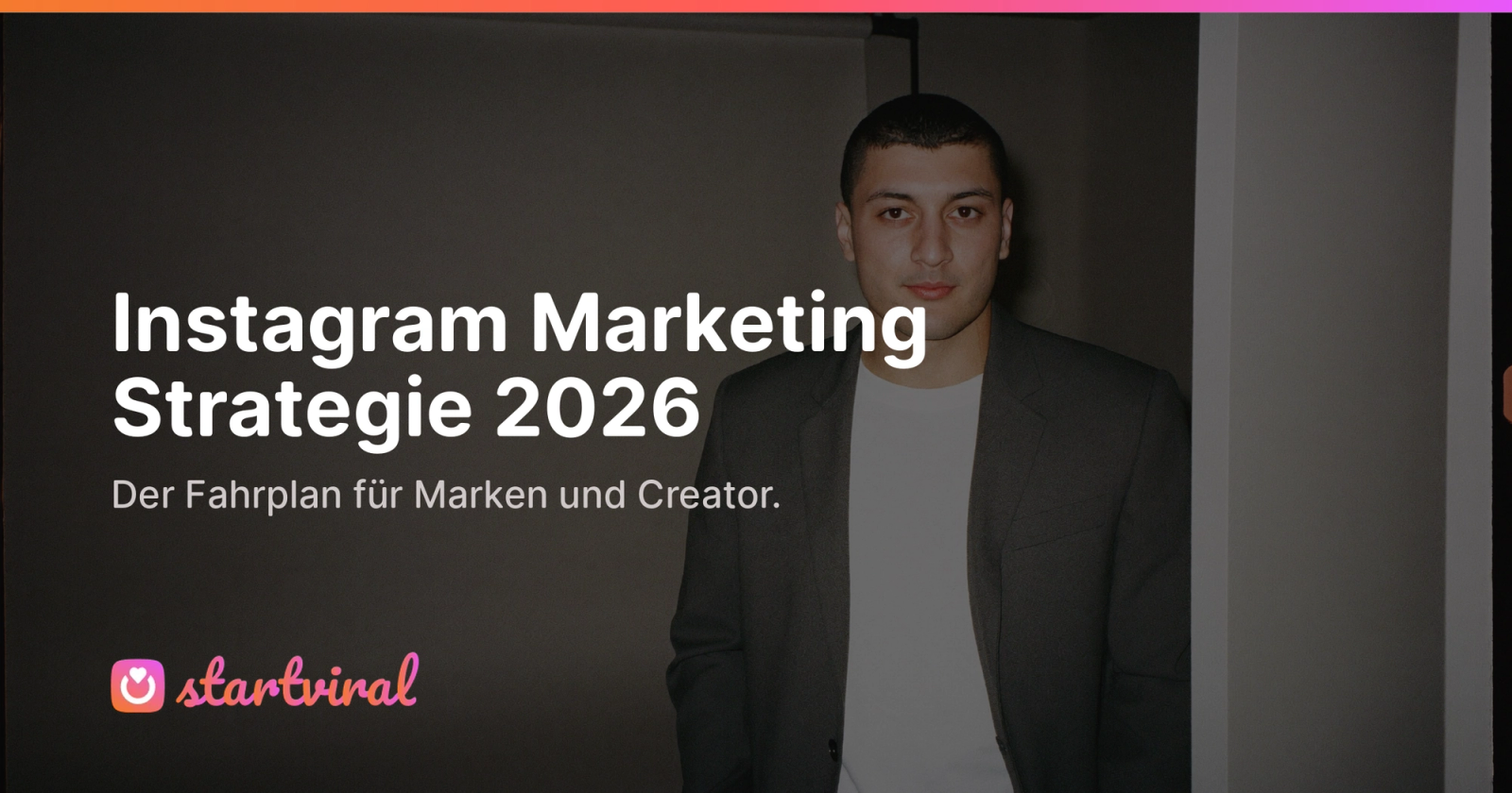 Junger Mann im dunklen Blazer in einem abgedunkelten Raum.