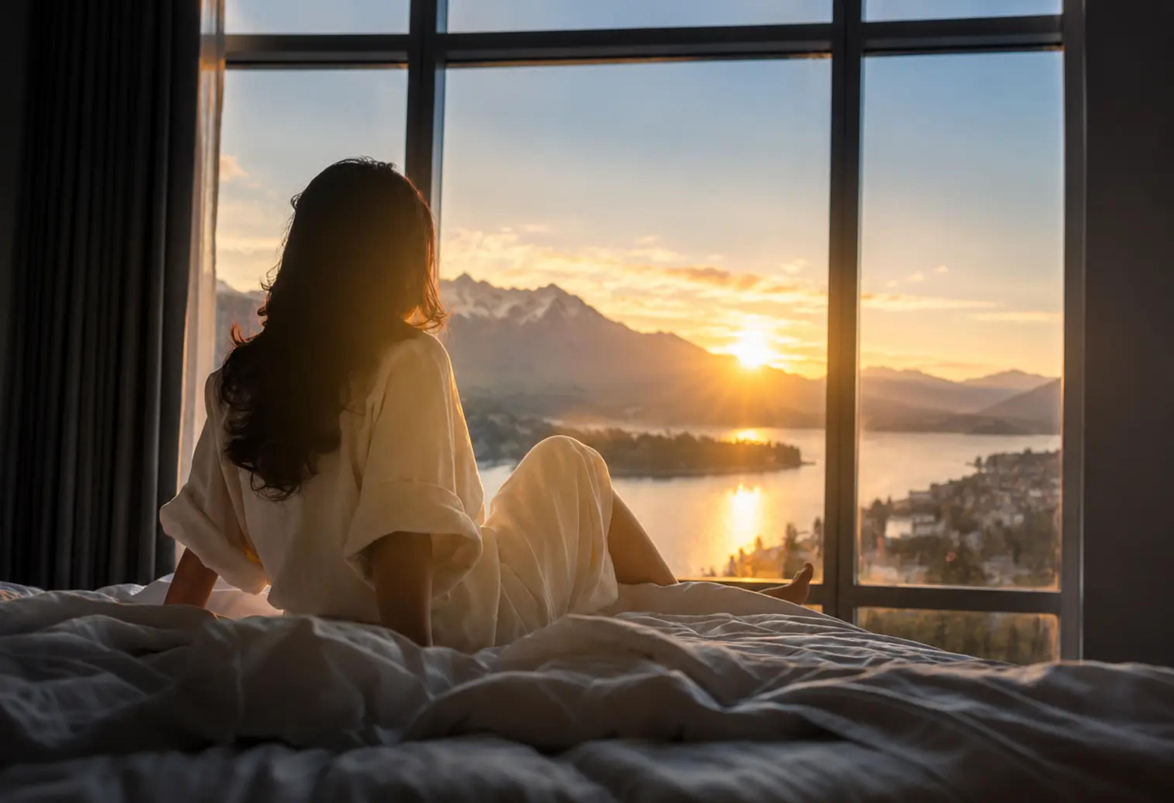 Guest enjoying sunrise over Lake Wakatipu from a Queenstown luxury holiday home
