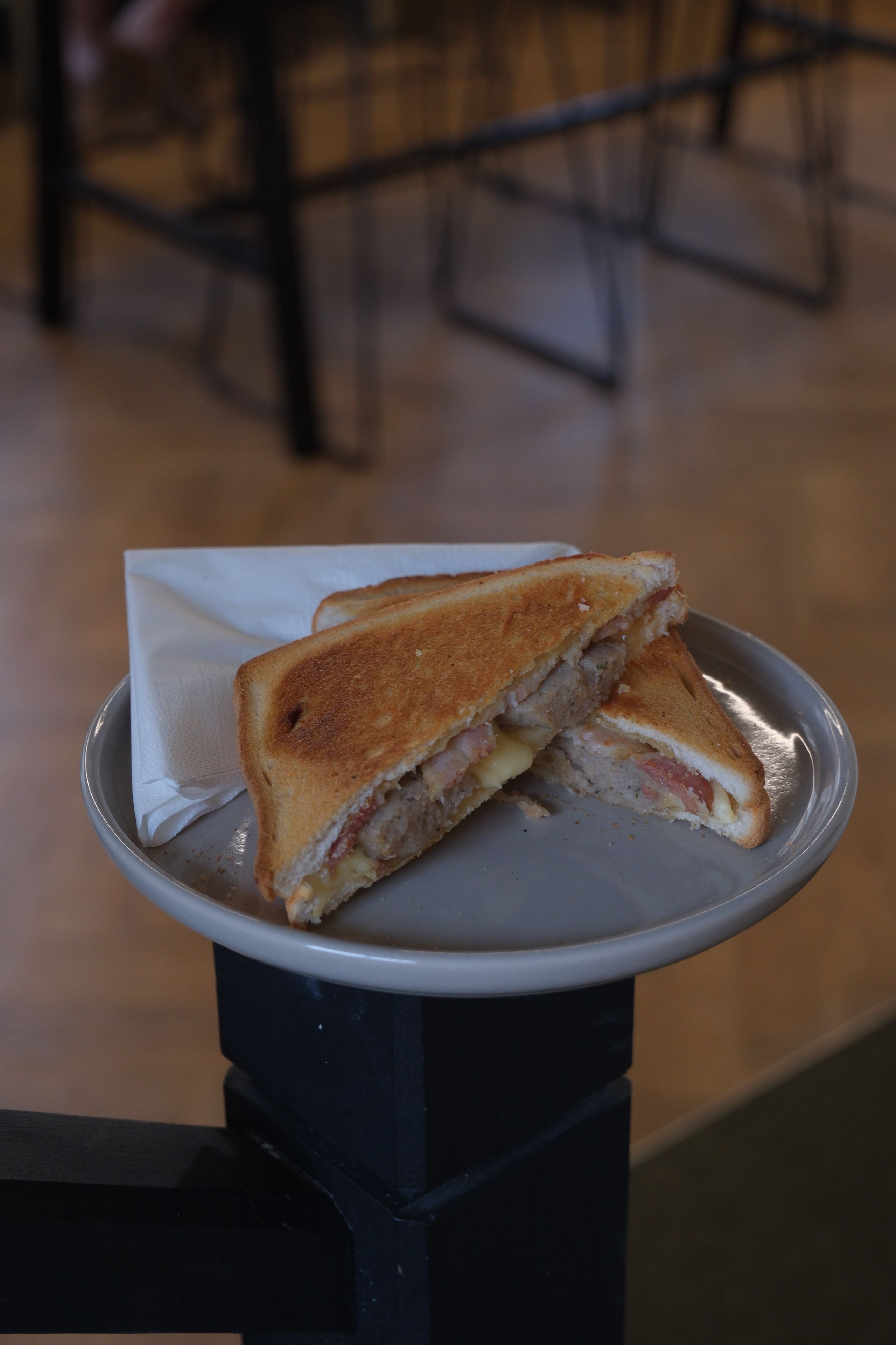 A breakfast bagel filled with sausage, bacon and egg