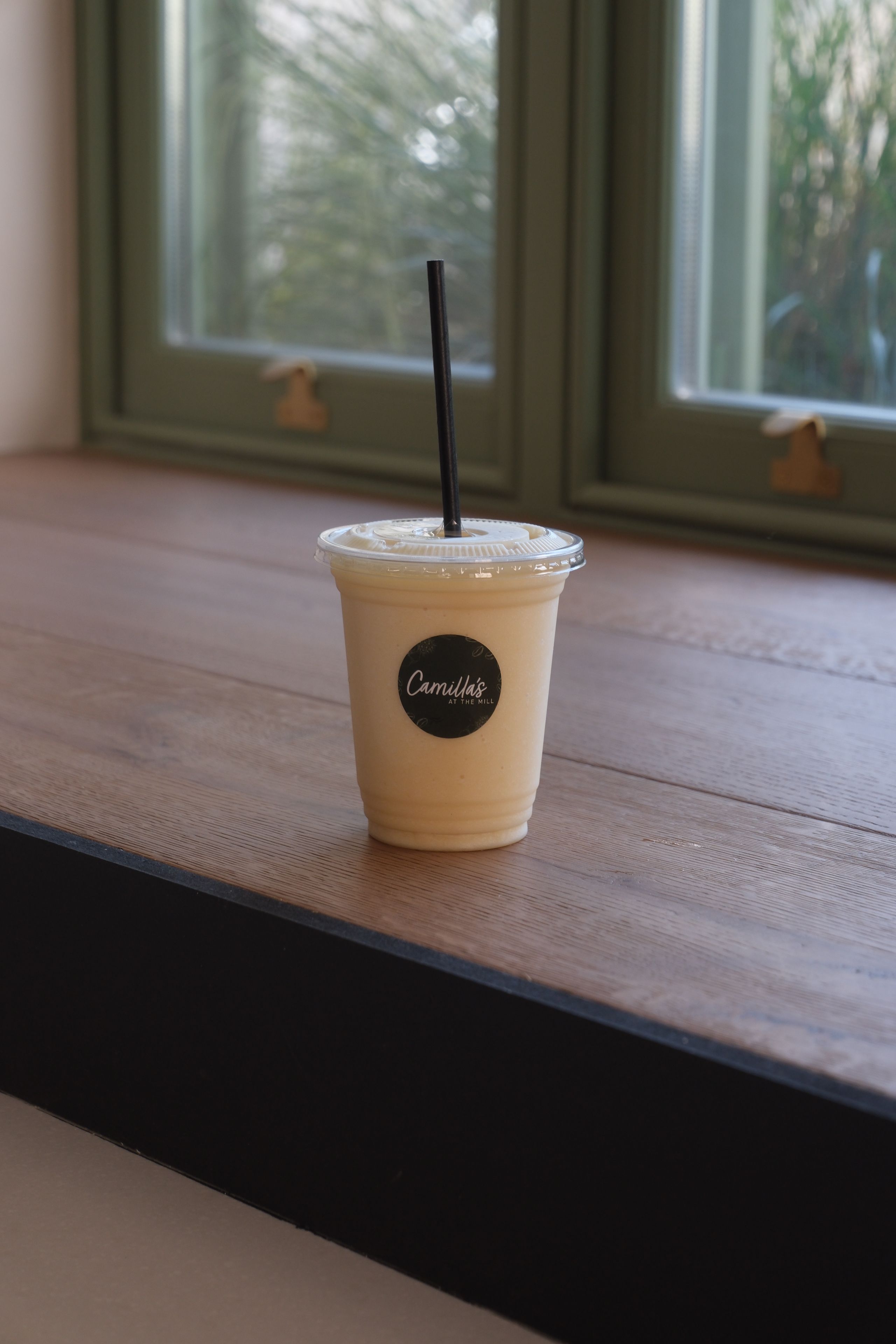 A coconut and pineapple smoothie in a glass