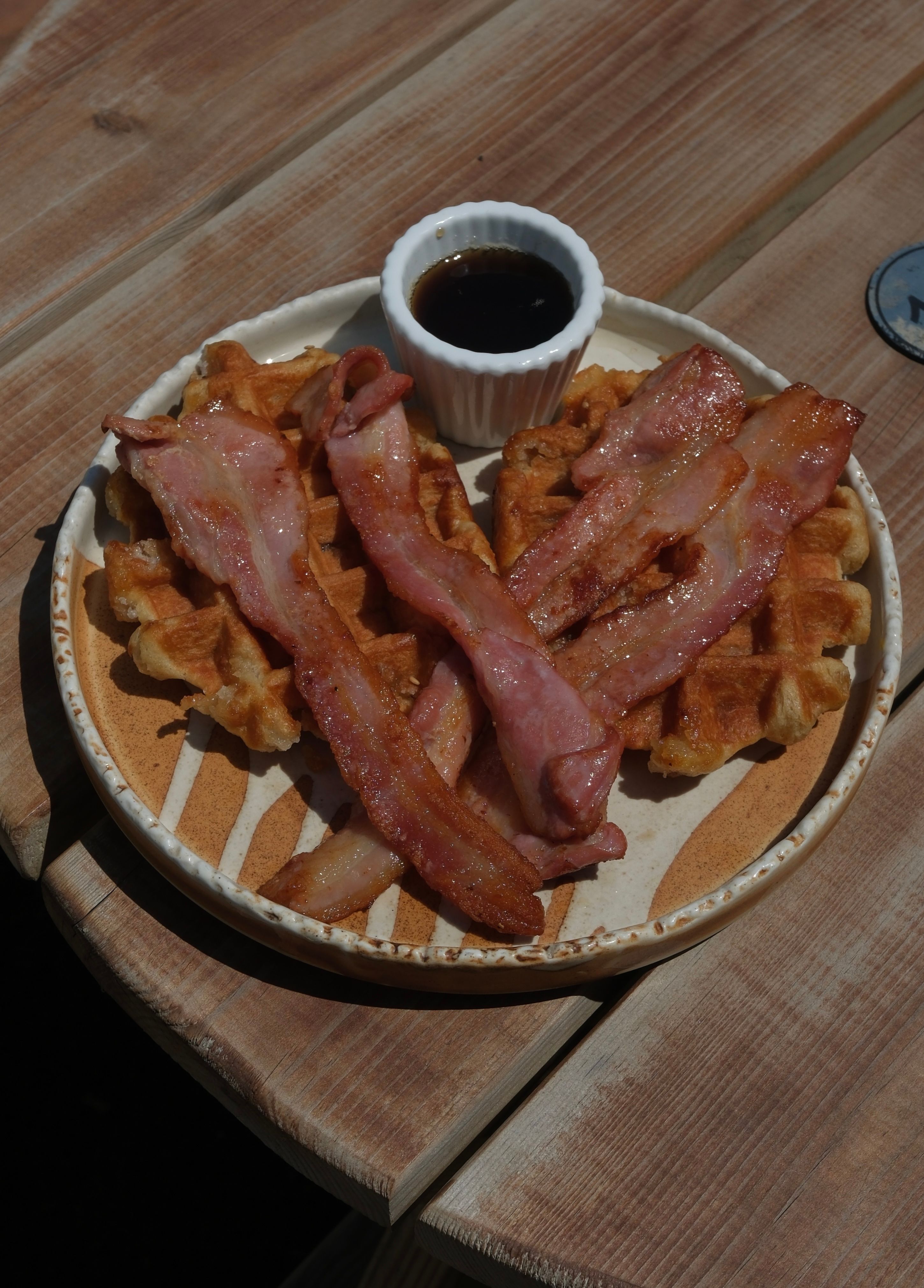 Waffles topped with maple syrup and crispy bacon