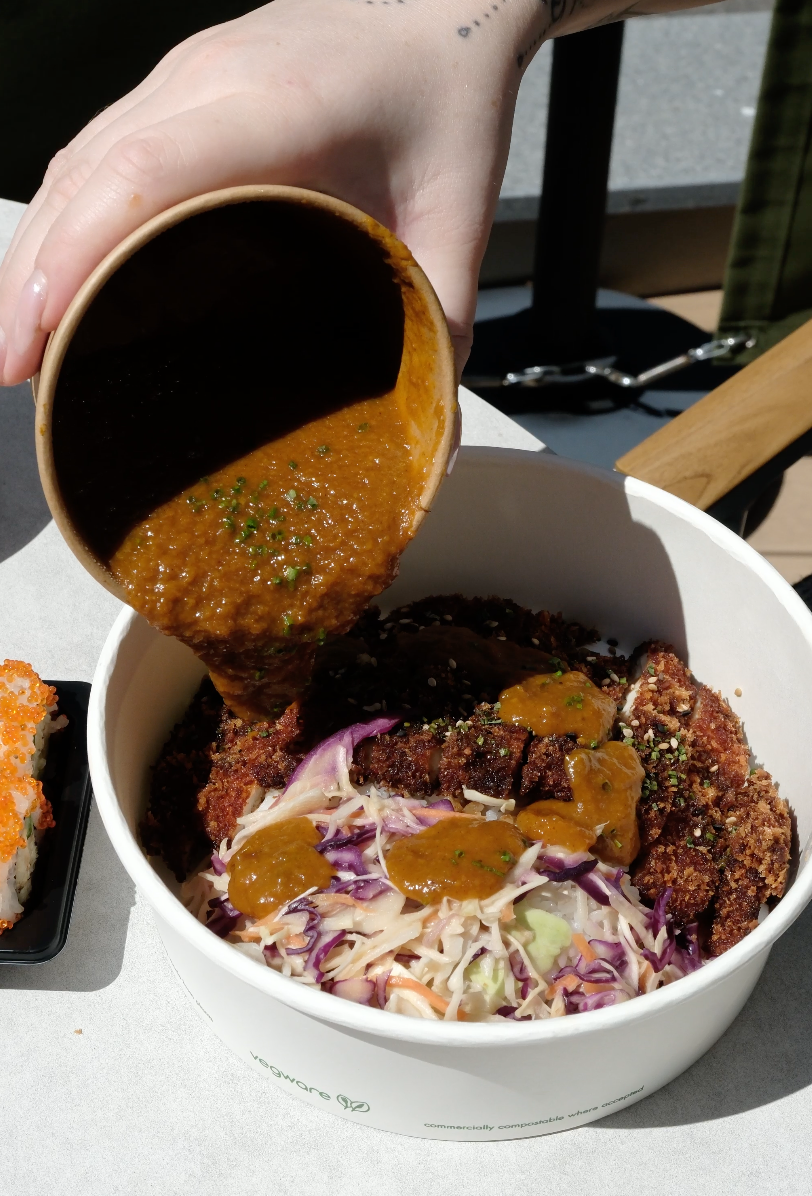 breaded chicken curry served on a bed of rice and pickled cabbage