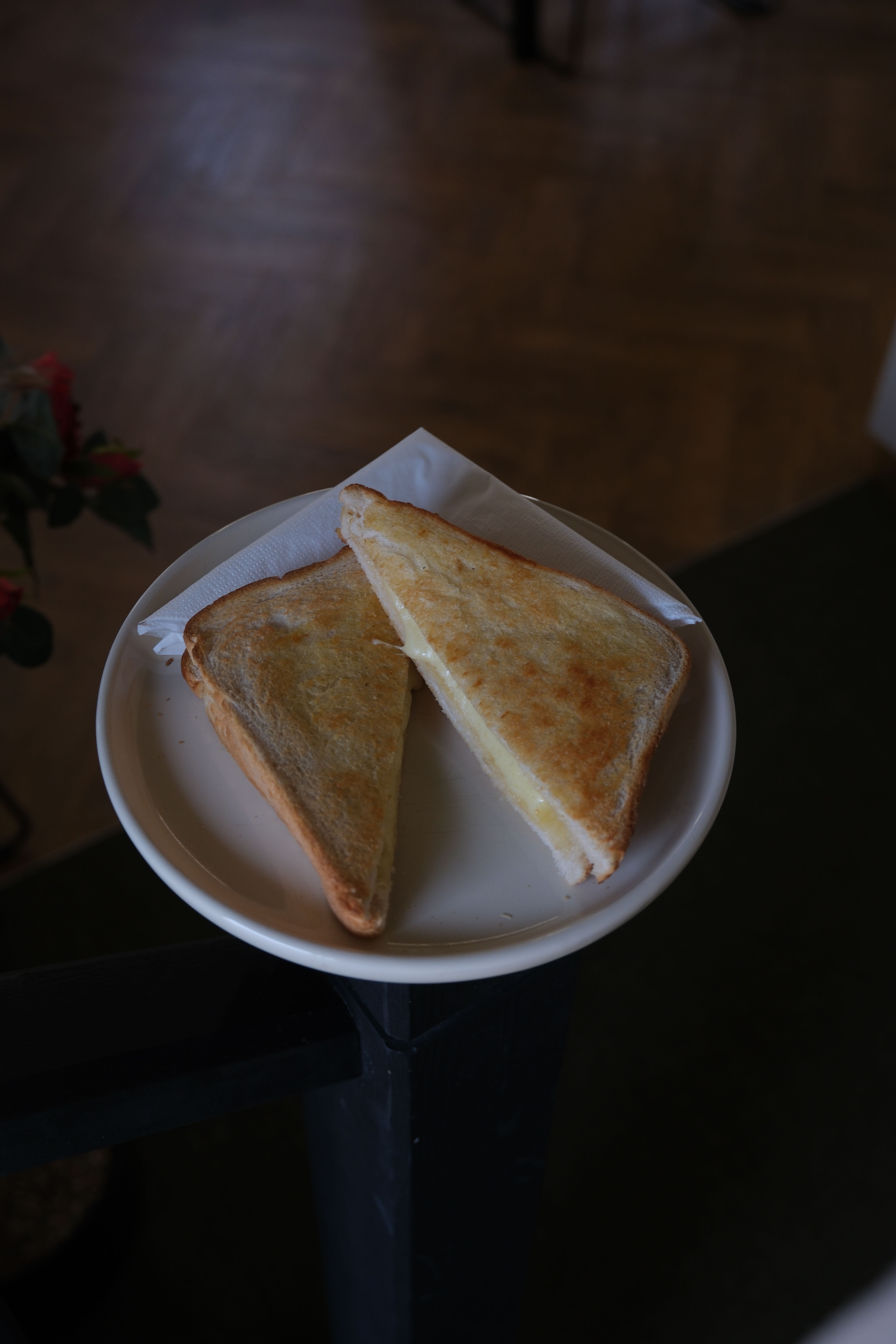 Grilled cheese sandwich cut in half on a white plate.