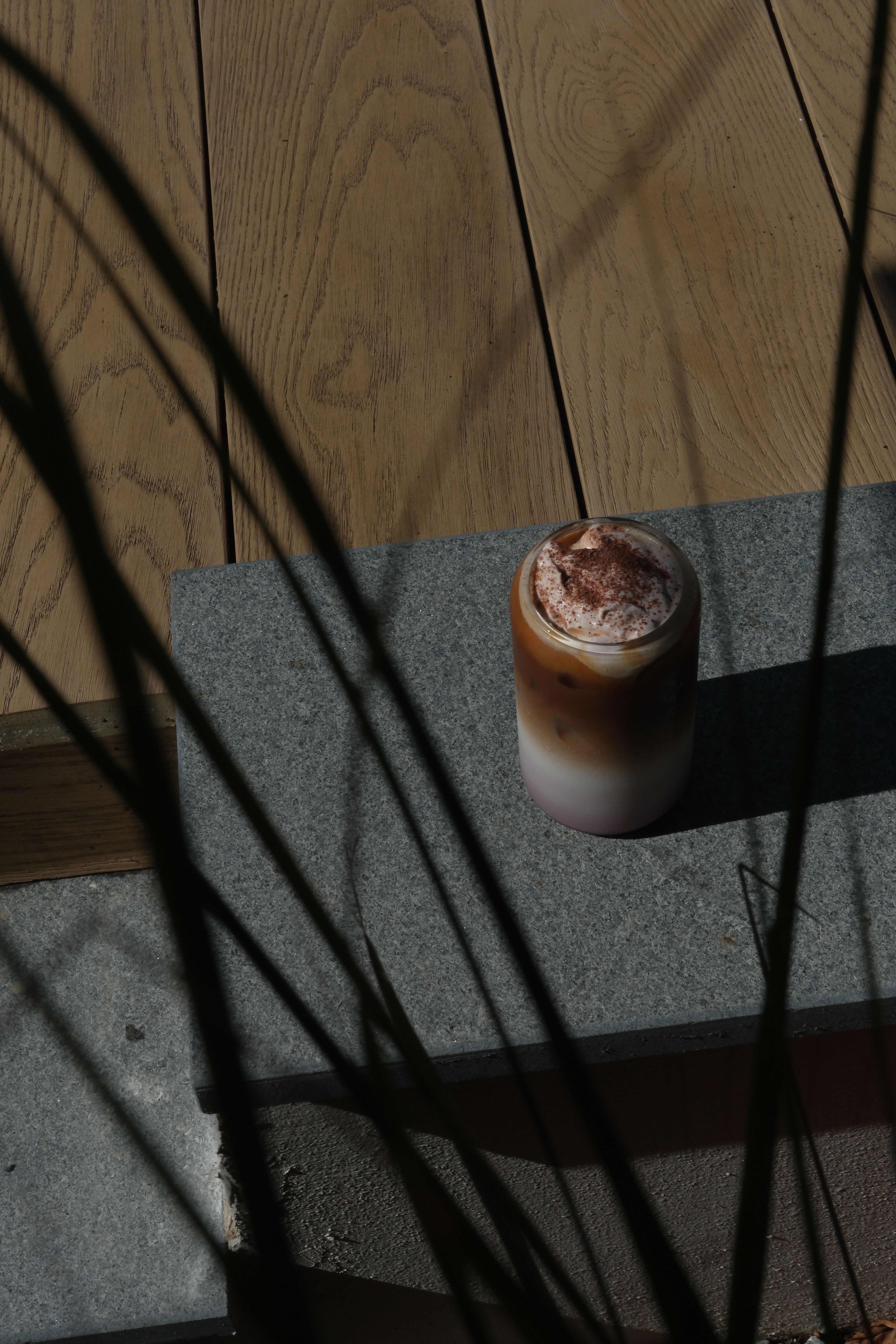 An iced coffee with cold foam in a tall glass