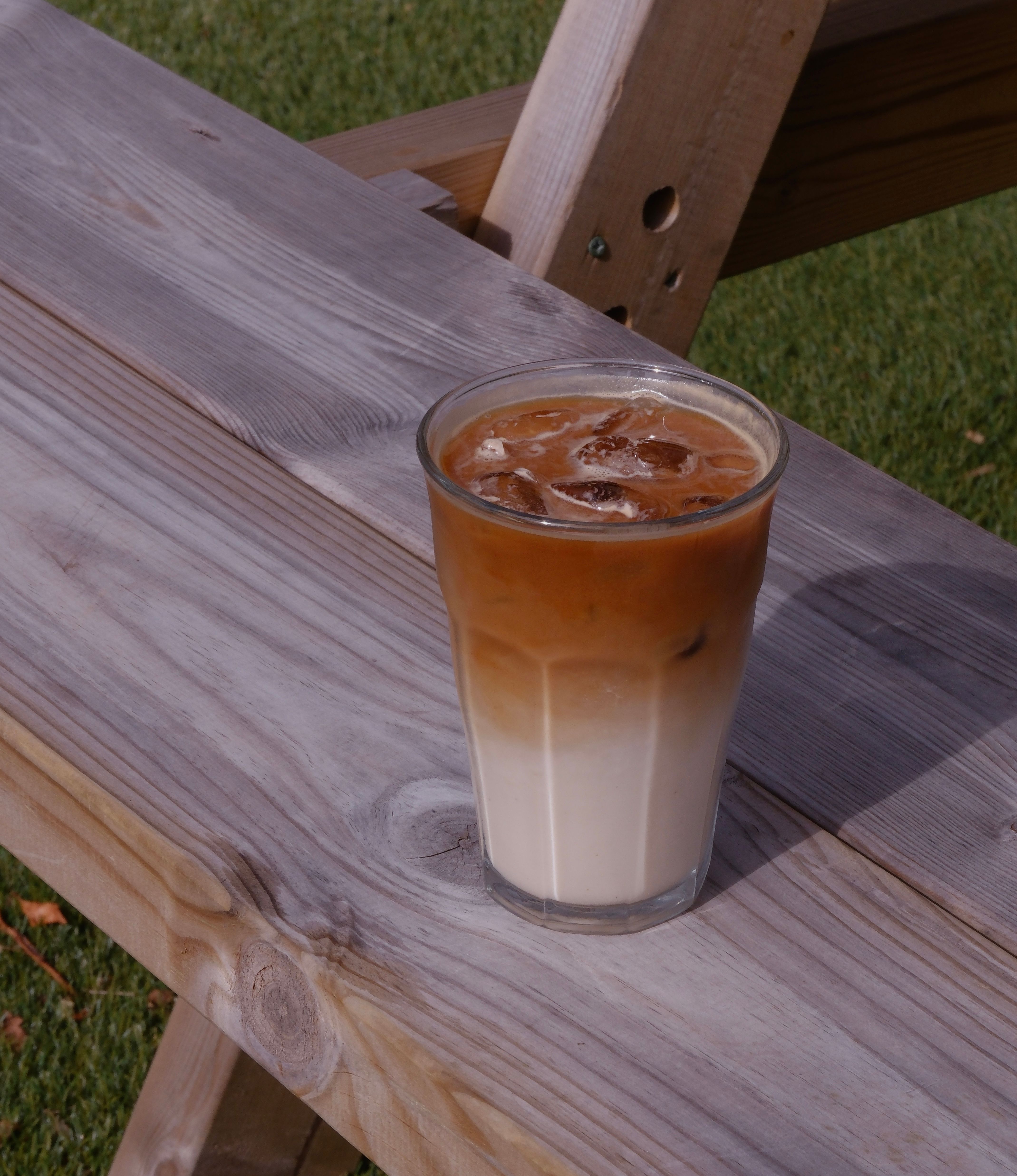 An iced latte in a tall glass with ice